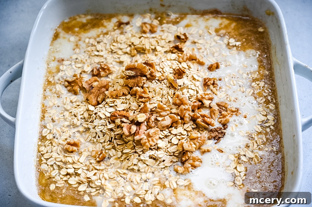 Delicious and Nutritious Banana Bread Baked Oatmeal 6 A close-up of a serving of Banana Bread Baked Oatmeal in a bowl, topped with a generous swirl of peanut butter and a few banana slices.