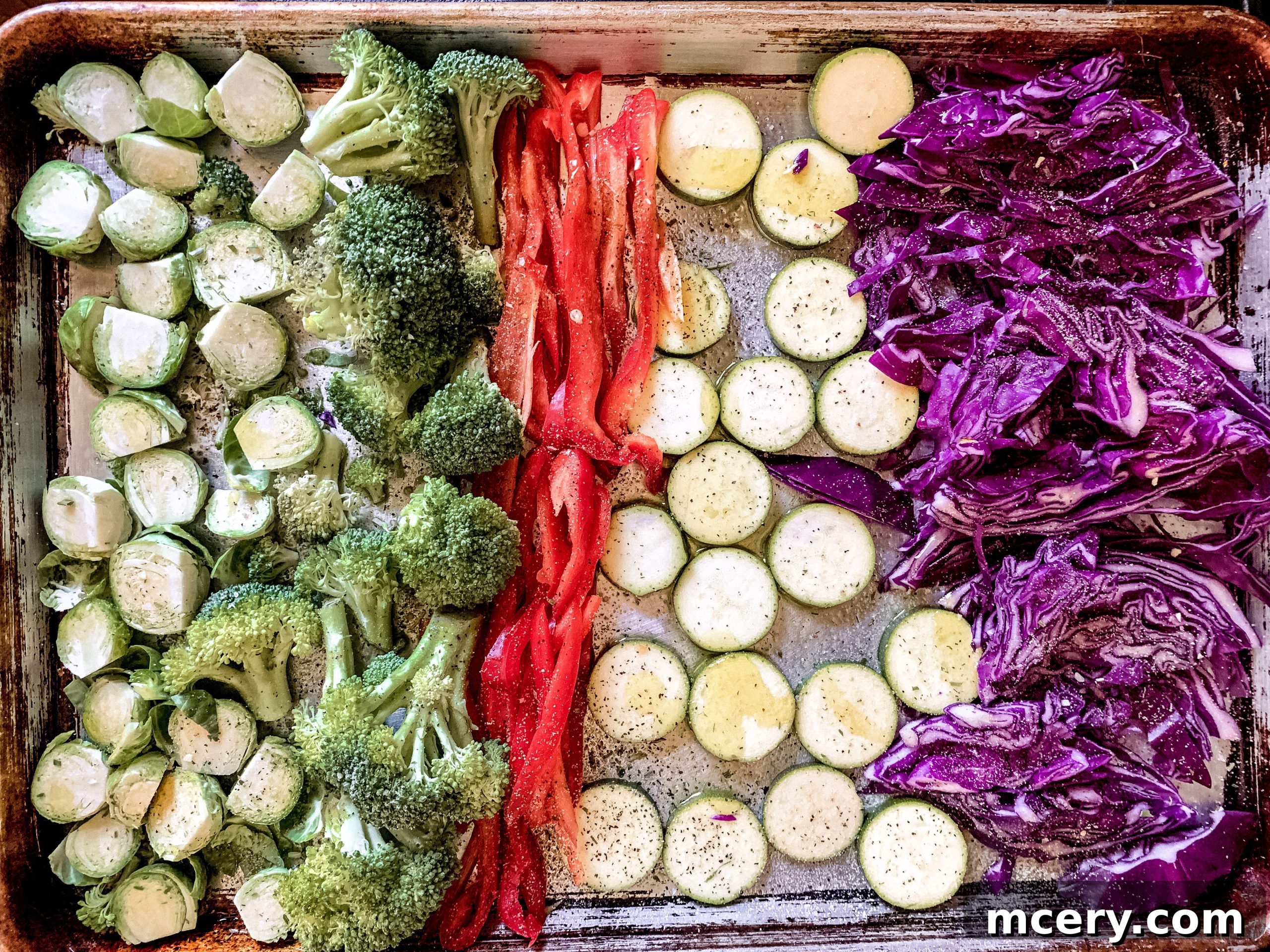 Wholesome Roasted Vegetable Quinoa Bowls 3 Close-up of freshly roasted vegetables, including sliced zucchini, bell peppers, and halved Brussels sprouts, glistening with olive oil and spices on a baking sheet, ready to be incorporated into a quinoa bowl.