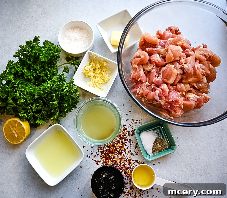 Sticky Sweet Garlic Chicken Bites 4 Various ingredients for honey garlic chicken, including raw chicken, honey, garlic cloves, lemon, and spices, neatly arranged on a wooden board.