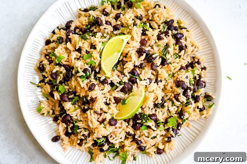 Perfect One-Pot Black Beans and Rice Side 9 A close-up of a serving of fluffy Black Beans & Rice with fresh cilantro, lime wedges, and a fork, highlighting its inviting texture and vibrant garnishes against a rustic backdrop, ready for a delicious meal.
