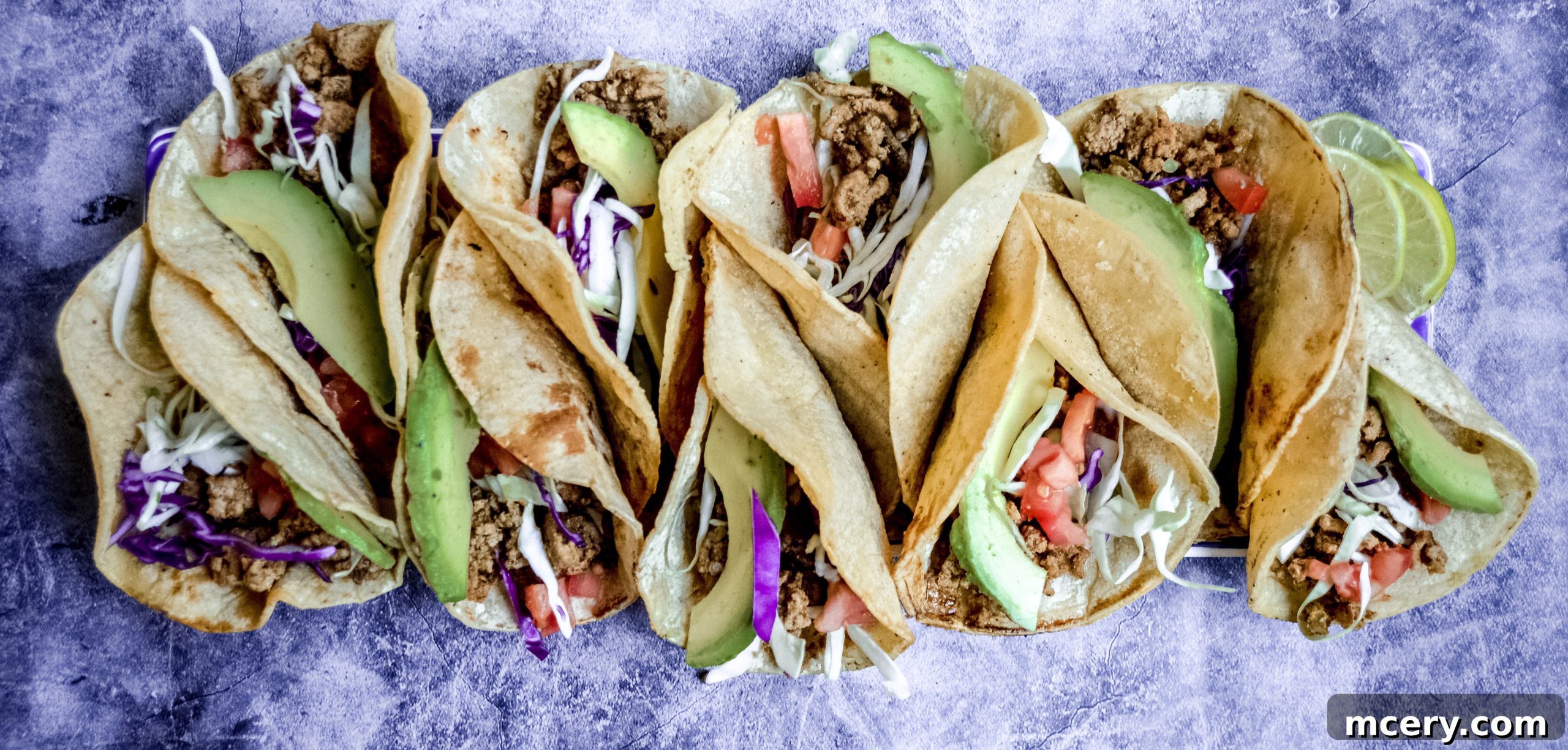 Flavorful & Fast Turkey Tacos 10 A spread of fresh taco ingredients including sliced avocado, diced tomatoes, cilantro, and warm corn tortillas.