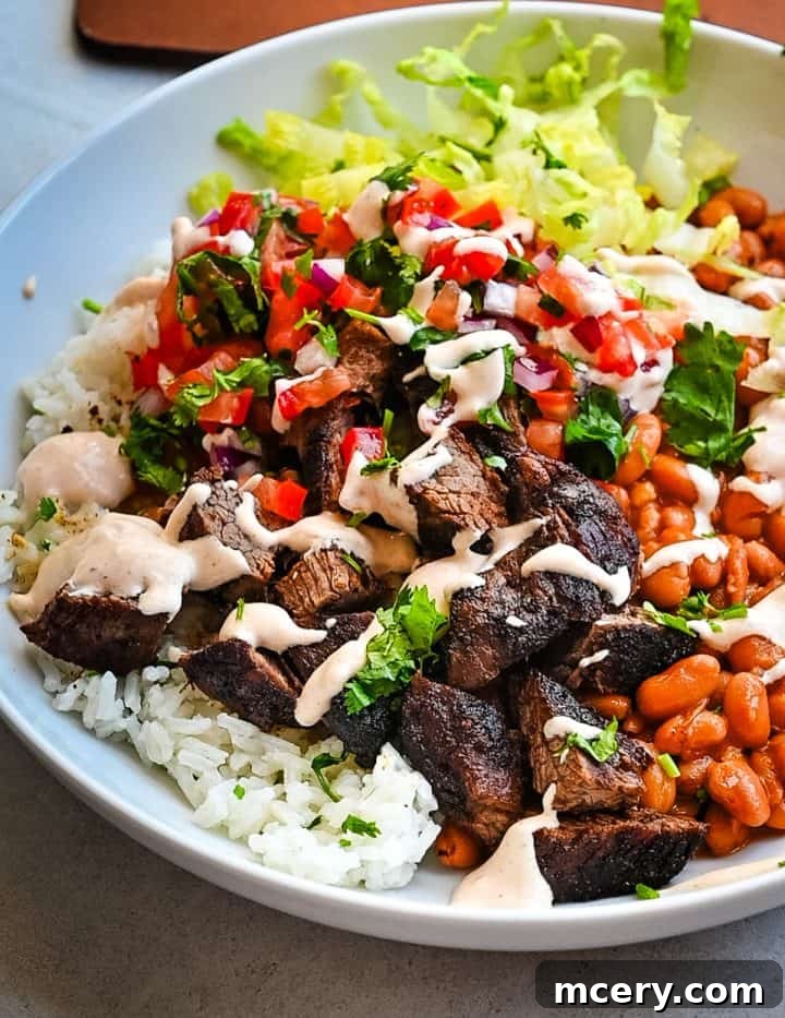 Smoky Chipotle Steak Bowls 3 A close-up shot of the creamy chipotle sauce drizzled over a steak burrito bowl, highlighting its rich texture.