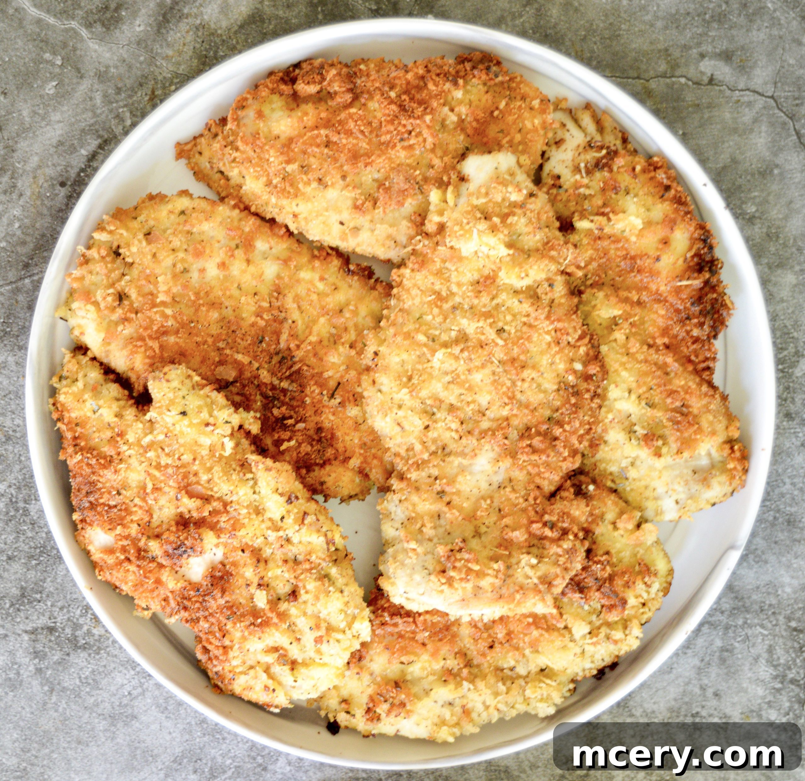 Parmesan Crusted Gluten-Free Chicken 6 A perfectly pan-fried Gluten-Free Parmesan Chicken Cutlet resting on paper towels.