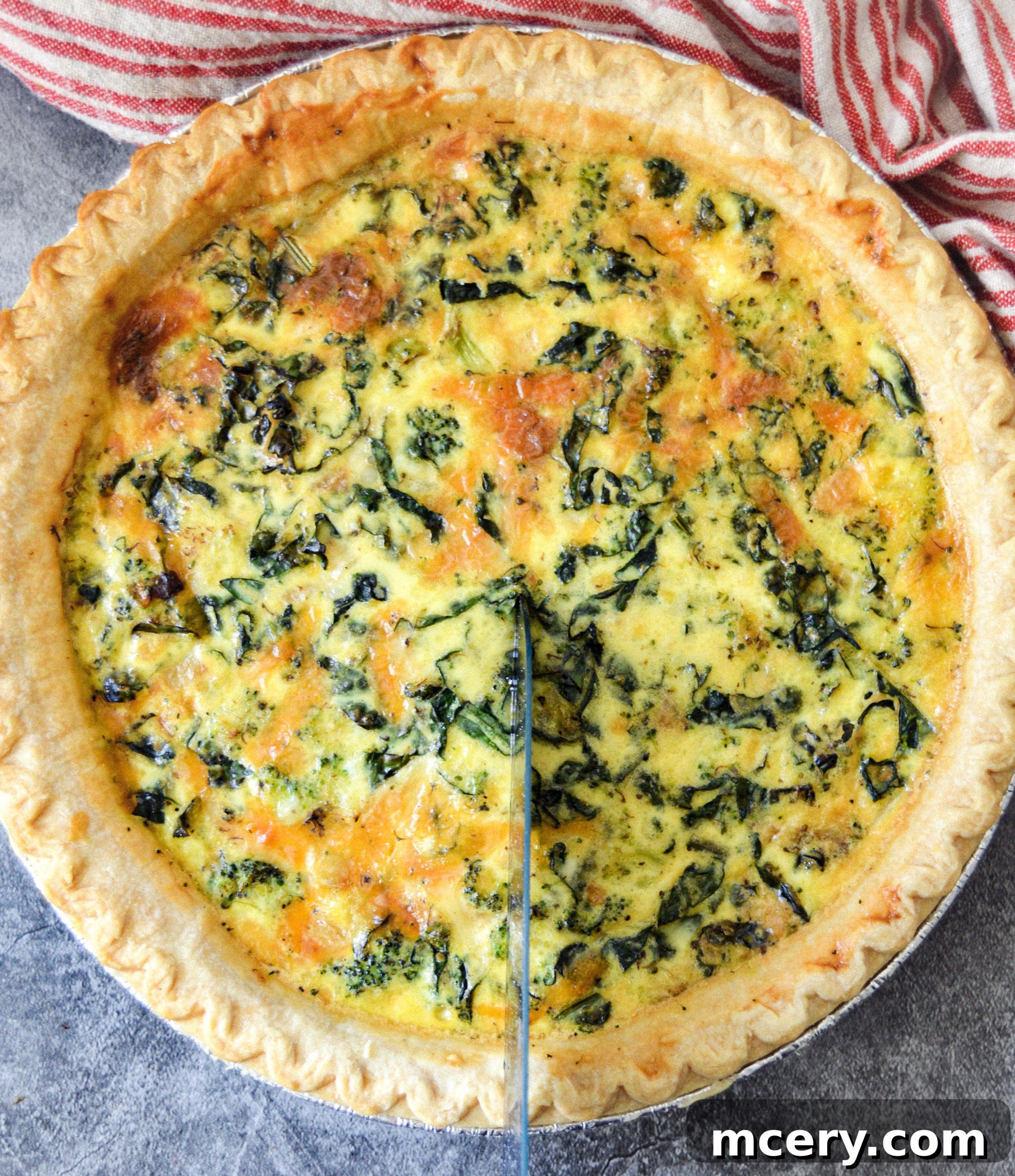 Wholesome Kale, Broccoli, and Cheddar Quiche 4 A close-up shot of a slice of quiche on a plate, showcasing the fluffy egg filling, visible pieces of kale and broccoli, and melted cheddar cheese.