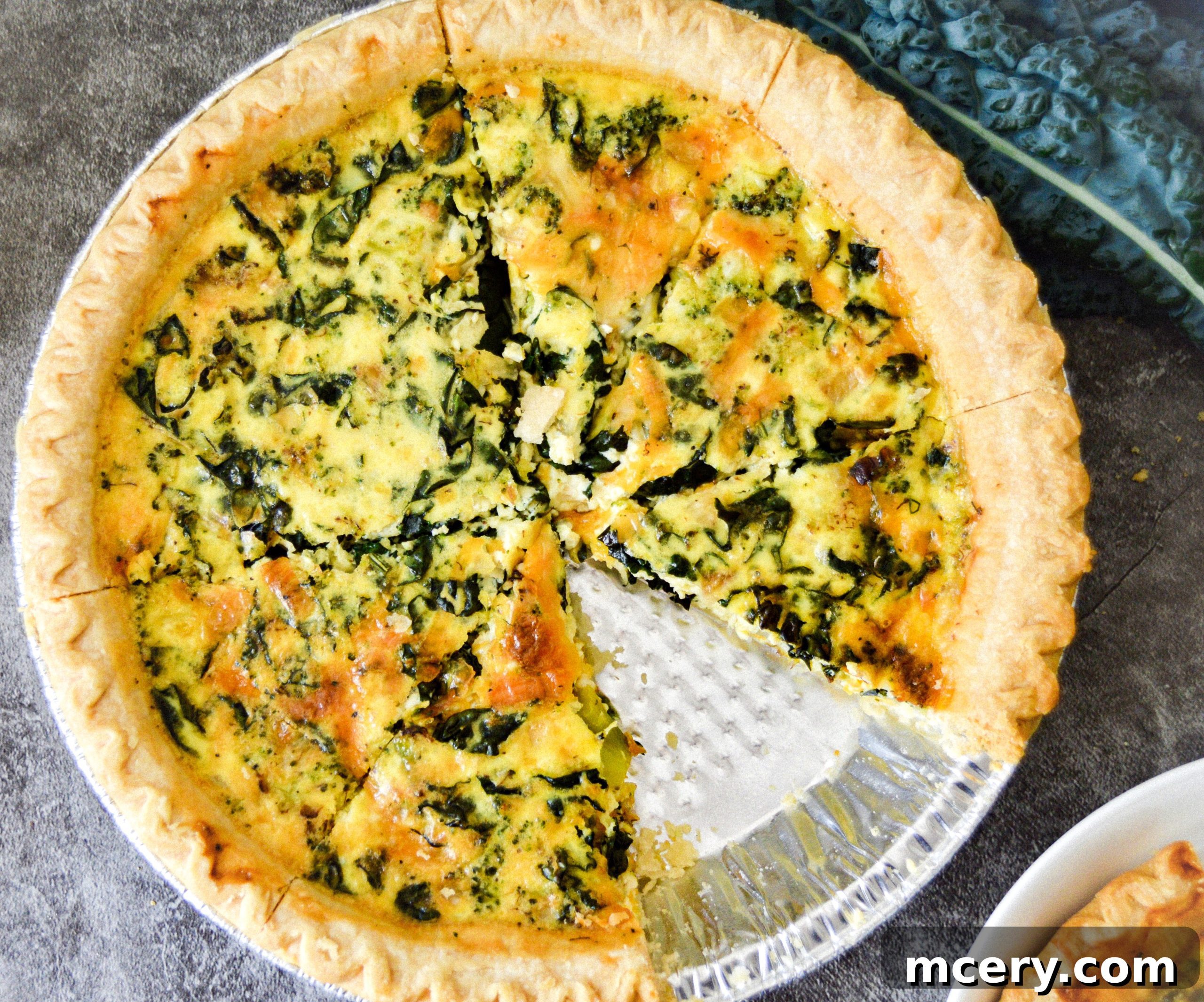Wholesome Kale, Broccoli, and Cheddar Quiche 6 A beautifully presented whole broccoli, kale, and cheddar quiche, garnished with fresh herbs, ready to be sliced.