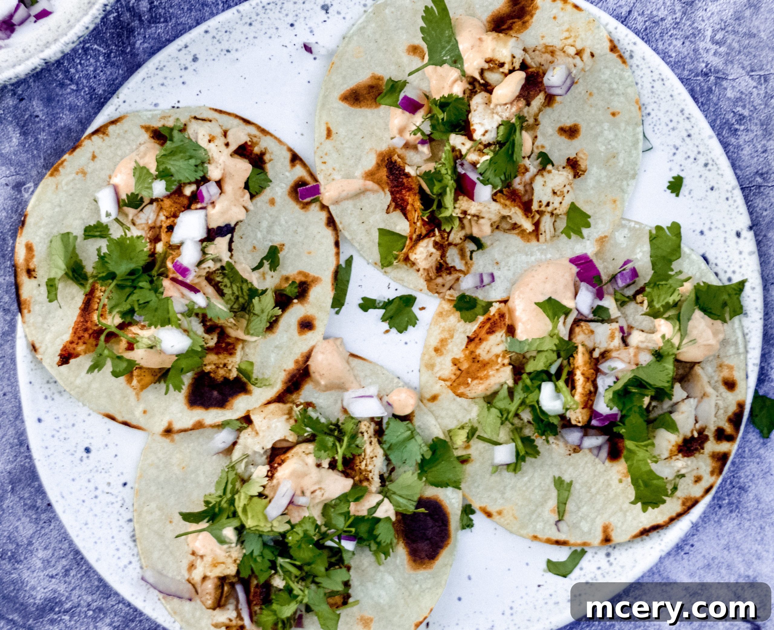 Zesty Street Chicken Tacos 2 Close-up of freshly made chicken street tacos garnished with vibrant cilantro and red onions, ready to be served.