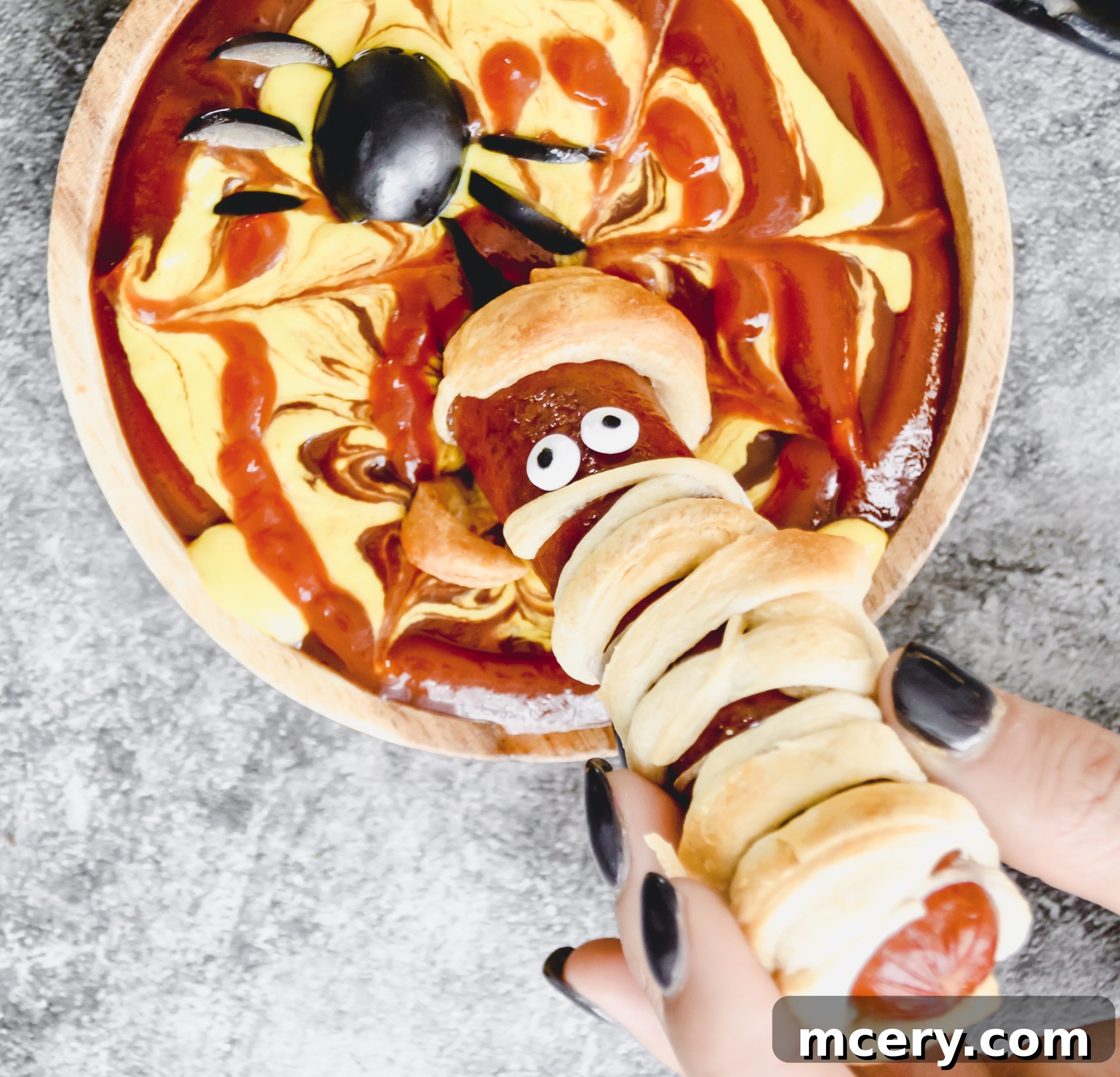 Halloweenie Wraps 4 Ingredients for Mummy Dogs laid out: a package of crescent rolls and several hot dogs on a cutting board, illustrating the simplicity of the recipe's components.