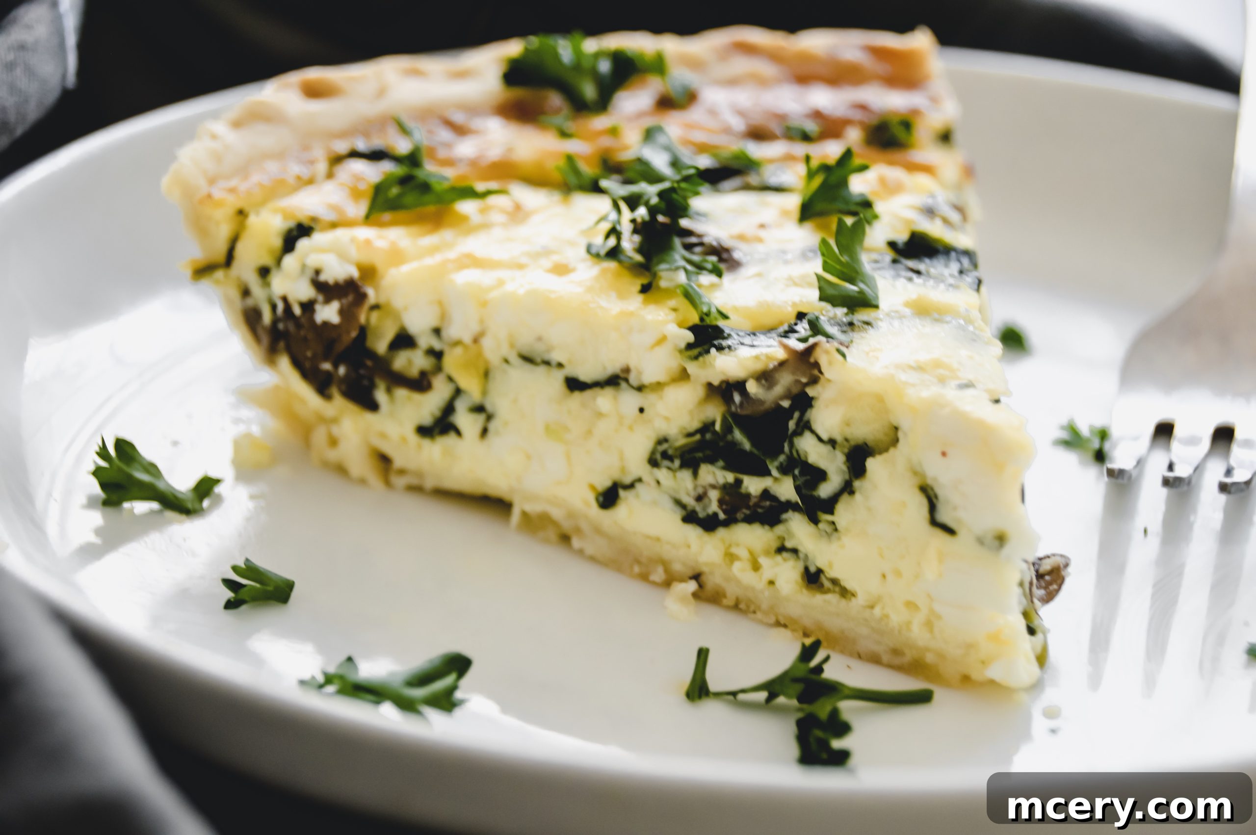 Overhead shot of a rustic Spinach, Mushroom, and Feta Quiche on a wooden board, showcasing its vibrant filling.