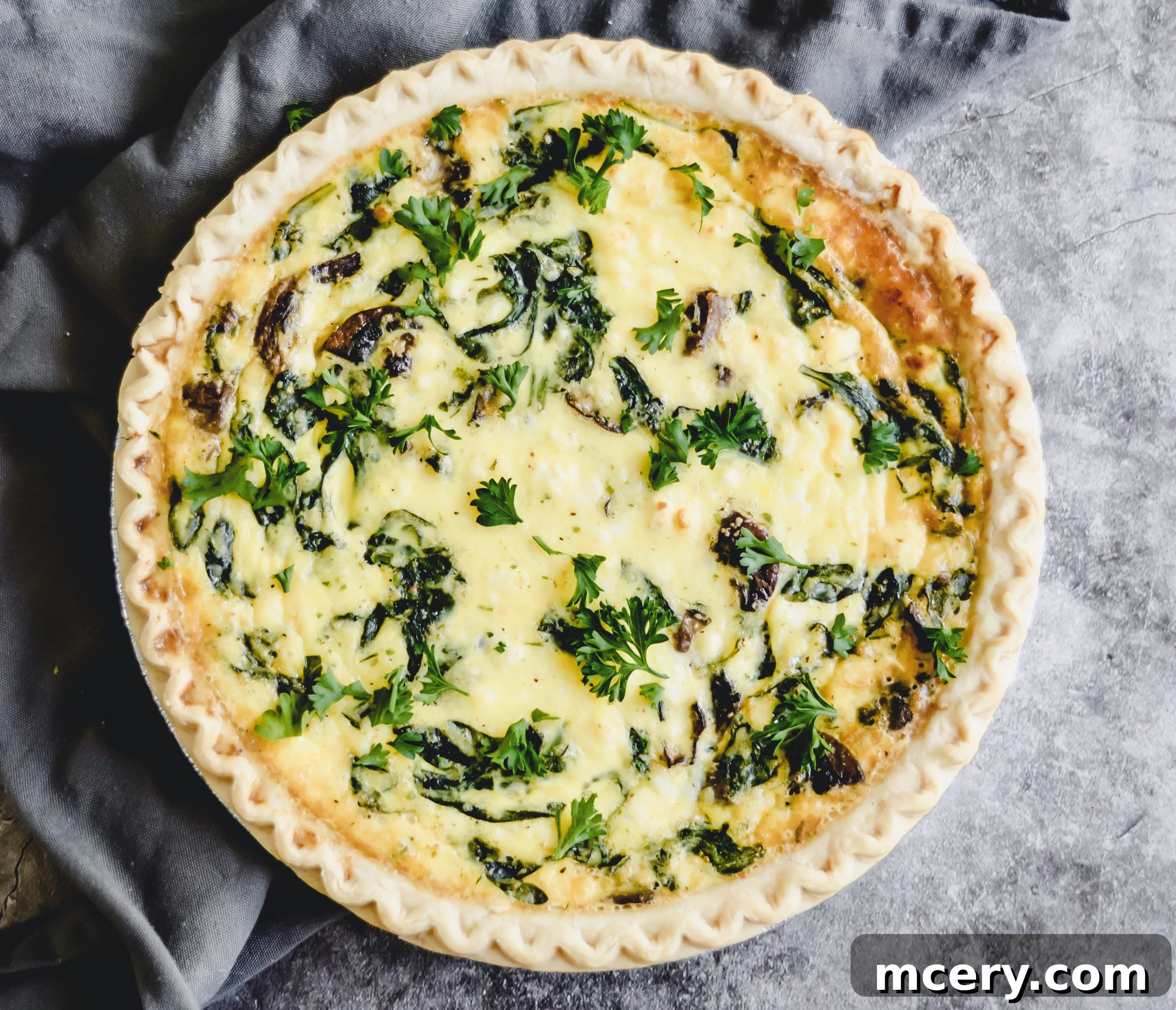 A golden, bubbly Spinach, Mushroom, and Feta Quiche fresh out of the oven, steam rising gently.