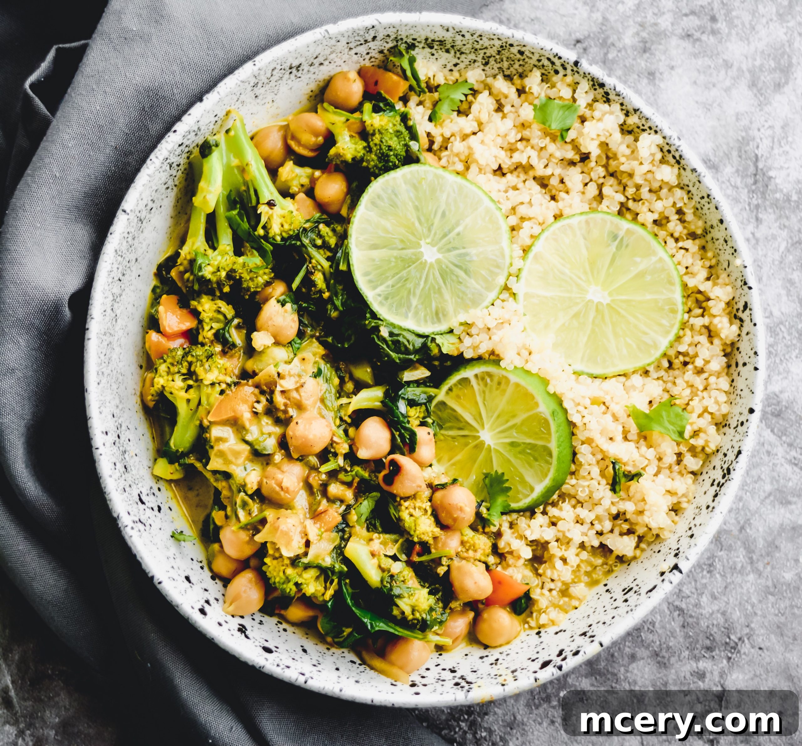 15-Minute Chickpea Curry Quinoa Power Bowl 2 A vibrant bowl of 15-Minute Chickpea Curry served with fluffy quinoa, garnished with fresh cilantro and lime wedges.