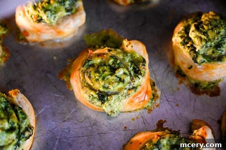 Savory Spinach and Cheese Puff Pastry Swirls 11 Close-up of flaky puff pastry on spinach and cheese pinwheel