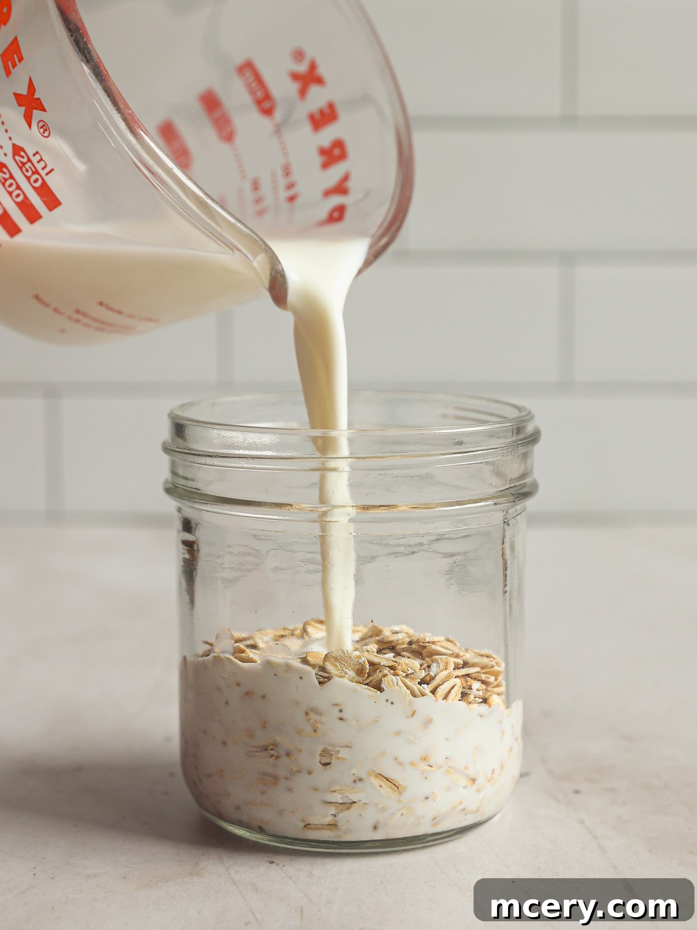 Overnight Oats Your Complete Guide to Oat Varieties and Preparation 5 Milk being poured over dry oats.