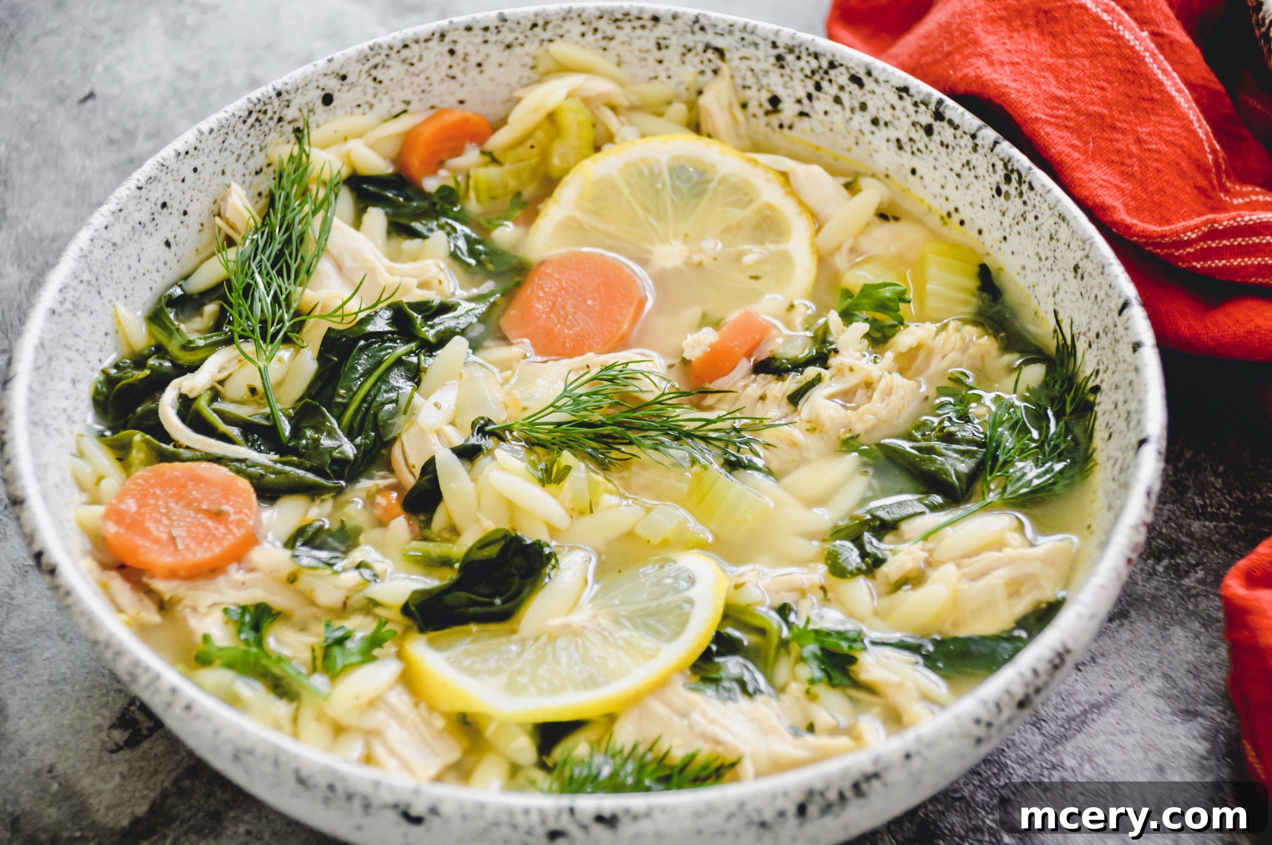 Zesty Instant Pot Lemon Chicken Orzo Soup 6 A spoonful of Lemon Chicken Orzo Soup being lifted from the bowl, showing its rich texture and ingredients.