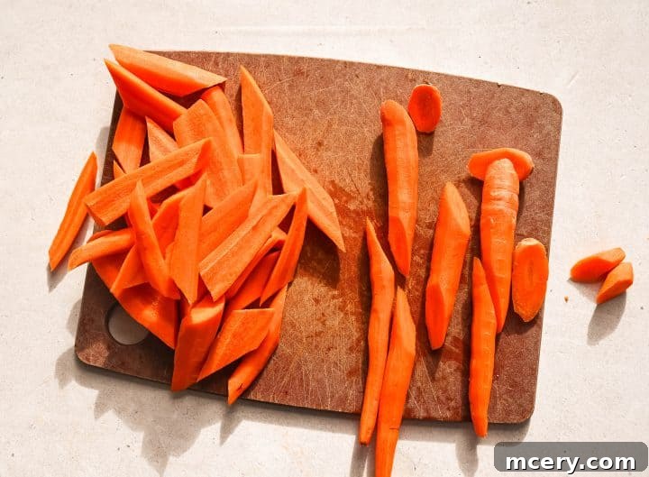 Golden Maple Glazed Carrots 4 Peeled and uniformly sliced carrots on a cutting board, ready for seasoning.