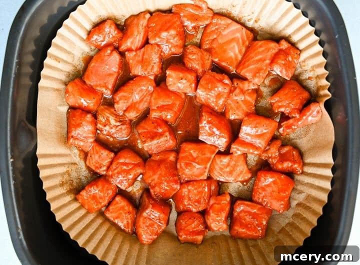 Honey Glazed Salmon Bites with Sesame Ginger and Smoked Paprika 7 Crispy honey baked salmon bites arranged on a parchment-lined plate, showing caramelized edges and glossy sesame-ginger glaze.