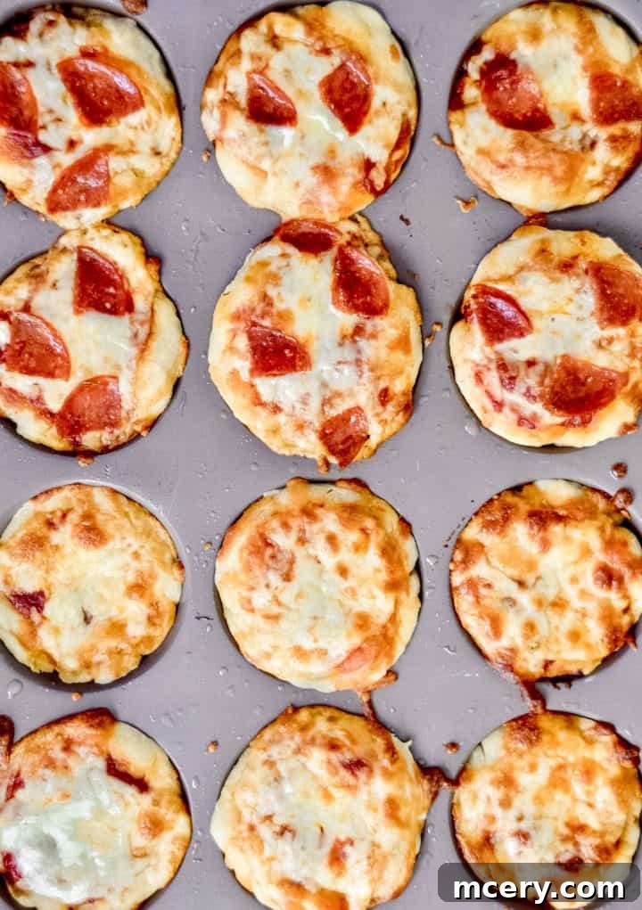 Easy Kid-Friendly Mini Pizza Bites for Meal Prep 2 Close-up of freshly baked mini pizza bites in a muffin tin, garnished with fresh basil leaves.