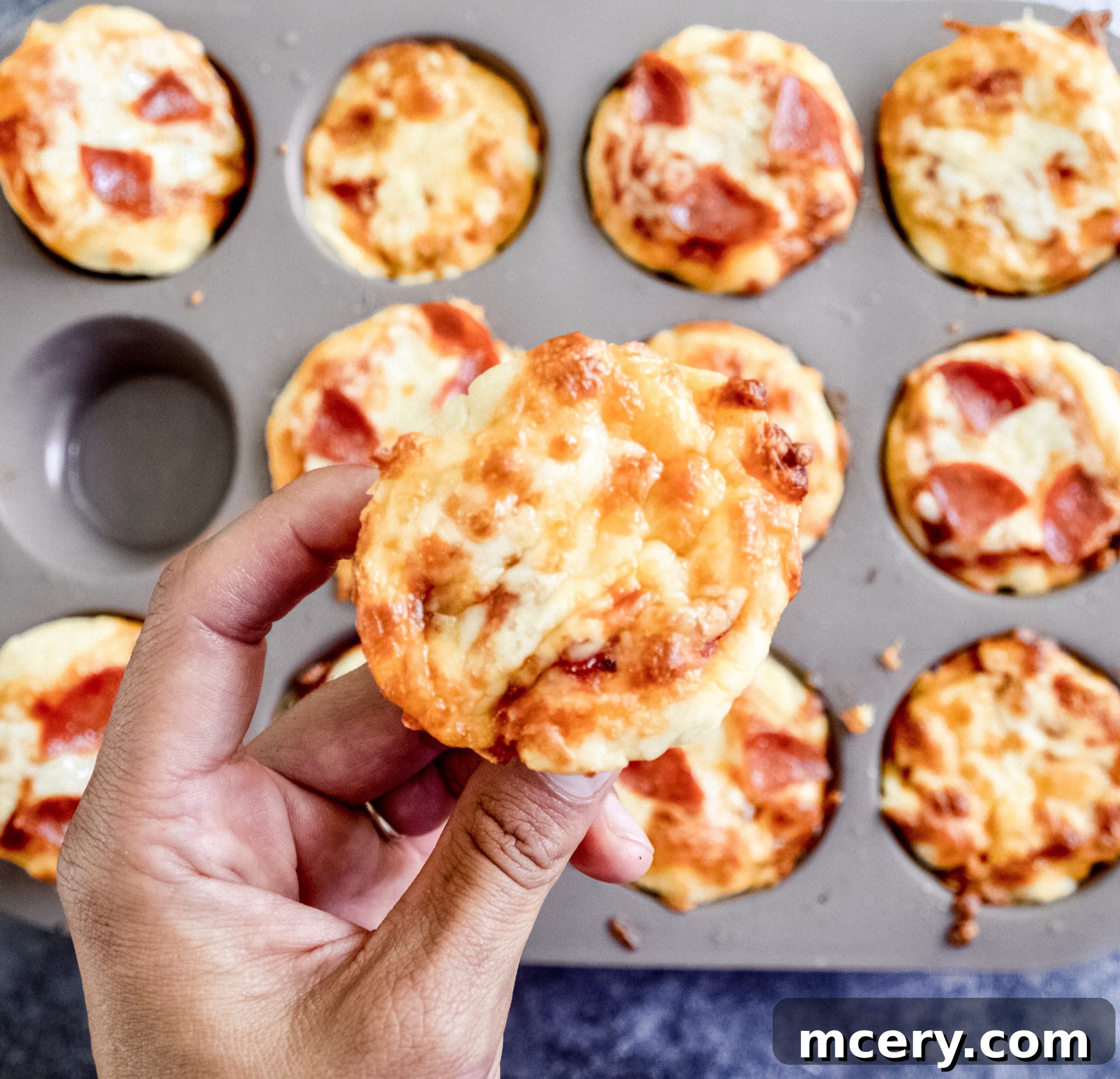 Easy Kid-Friendly Mini Pizza Bites for Meal Prep 4 A top-down view of cooked mini pizza bites with melted cheese and pepperoni, presented beautifully on a rustic wooden board.