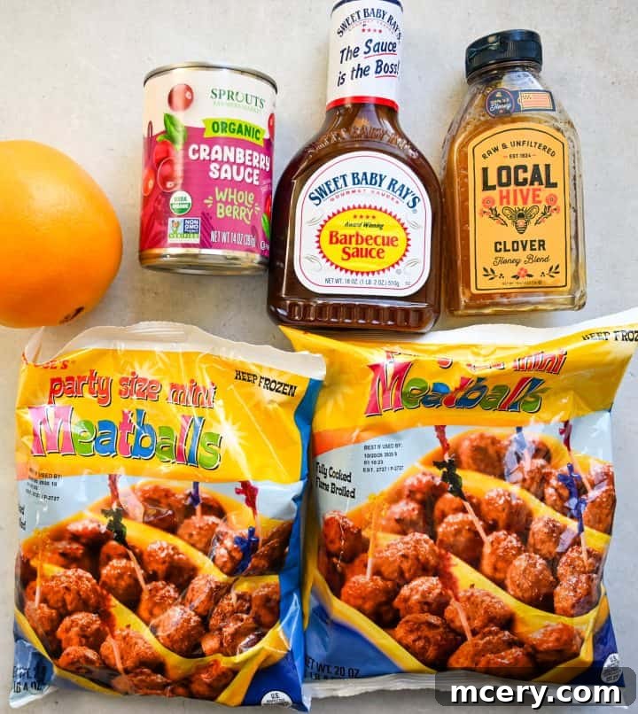 Cranberry Glazed Holiday Meatballs 3 Overhead view of ingredients for holiday meatballs, including frozen meatballs, barbecue sauce, hot honey, orange juice, and seasonings displayed on a rustic wooden board.