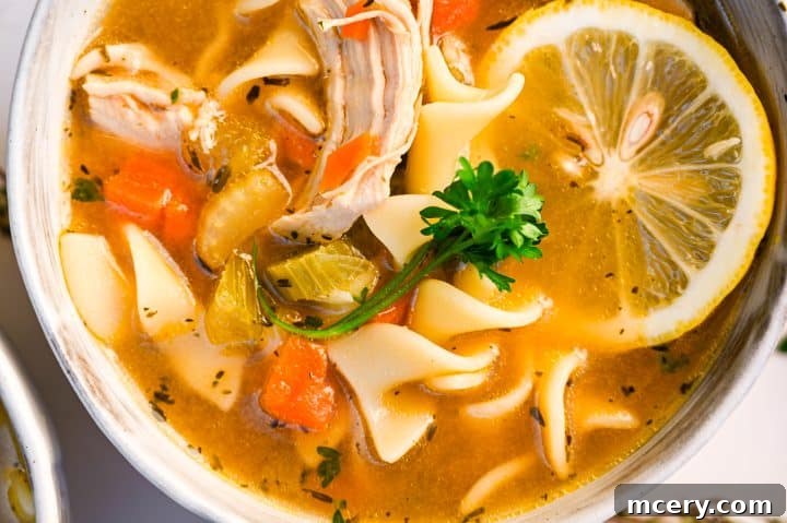 Soul Soothing Chicken Noodle Soup 12 A warm, inviting bowl of chicken noodle soup garnished with fresh parsley, sitting on a rustic wooden surface, exuding comfort and homemade goodness.