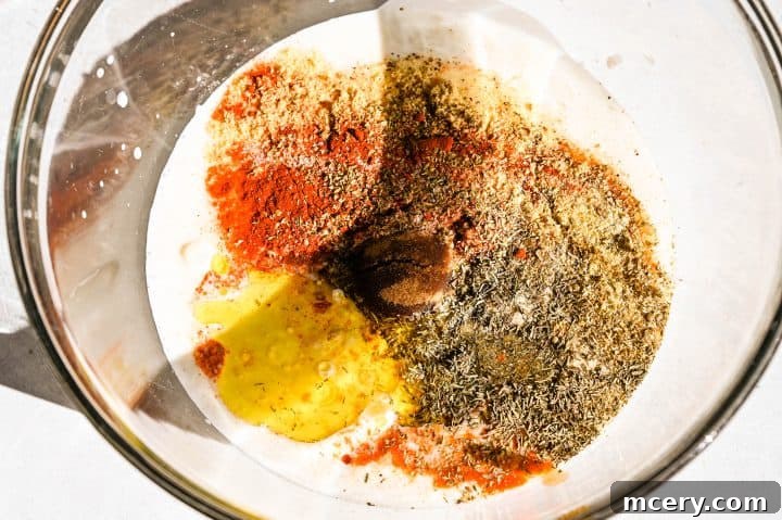 Buttermilk chicken pieces marinating in a large bowl, covered.