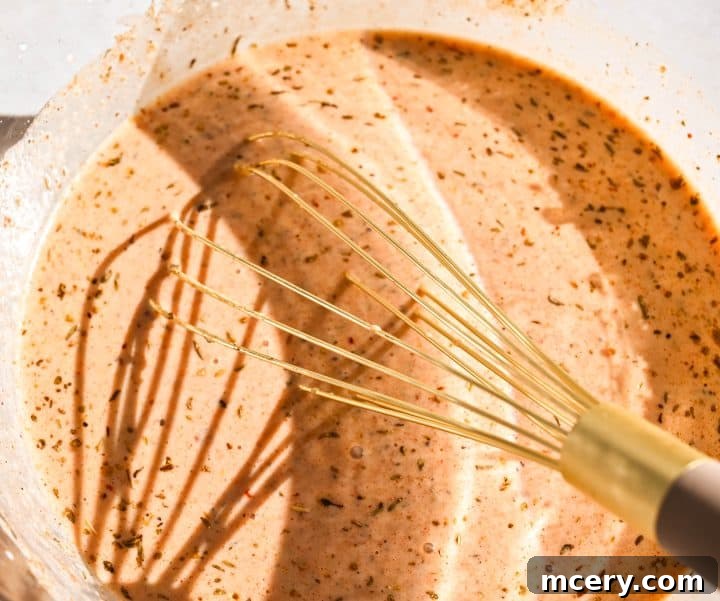 Chicken drumsticks coated in marinade, ready for baking.