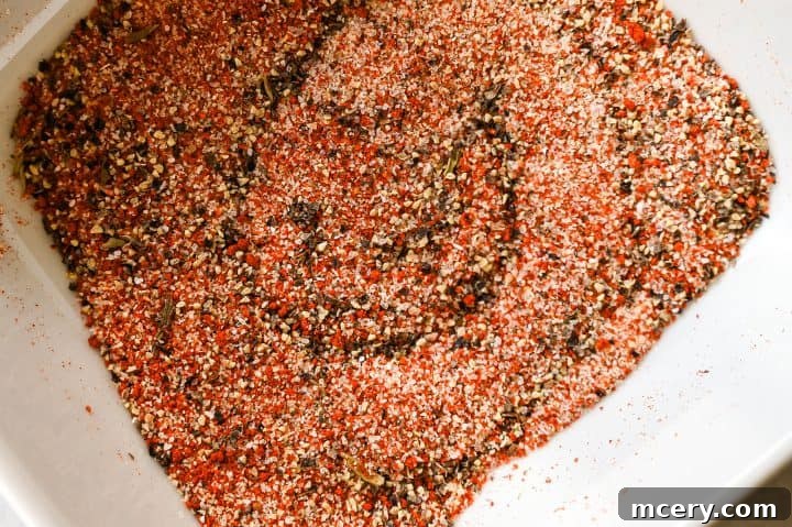 Close-up of crispy chicken skin being drizzled with garlic butter.