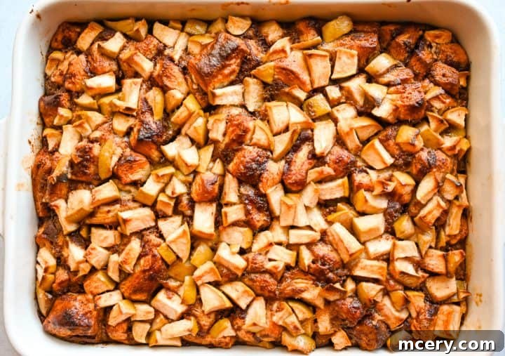 Golden Apple Cinnamon Pull-Apart Bake 13 Serving spoons taking a scoop of the Apple Cinnamon Roll Bake.