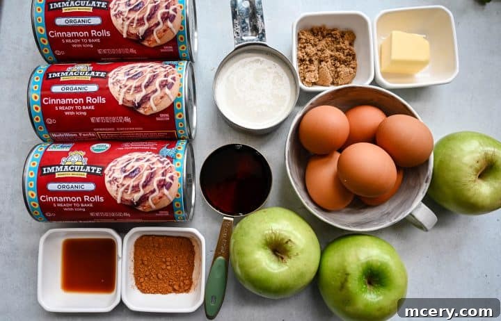 Golden Apple Cinnamon Pull-Apart Bake 4 Selection of ingredients for Apple Cinnamon Roll Bake including canned cinnamon rolls, eggs, heavy cream, apples, butter, and spices.
