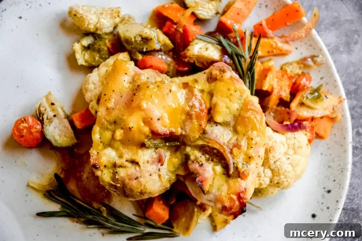 Honey-Glazed Rosemary Chicken with Flavorful Roasted Vegetables 4 A beautifully plated serving of Rosemary Honey Chicken with roasted vegetables, garnished with fresh rosemary.