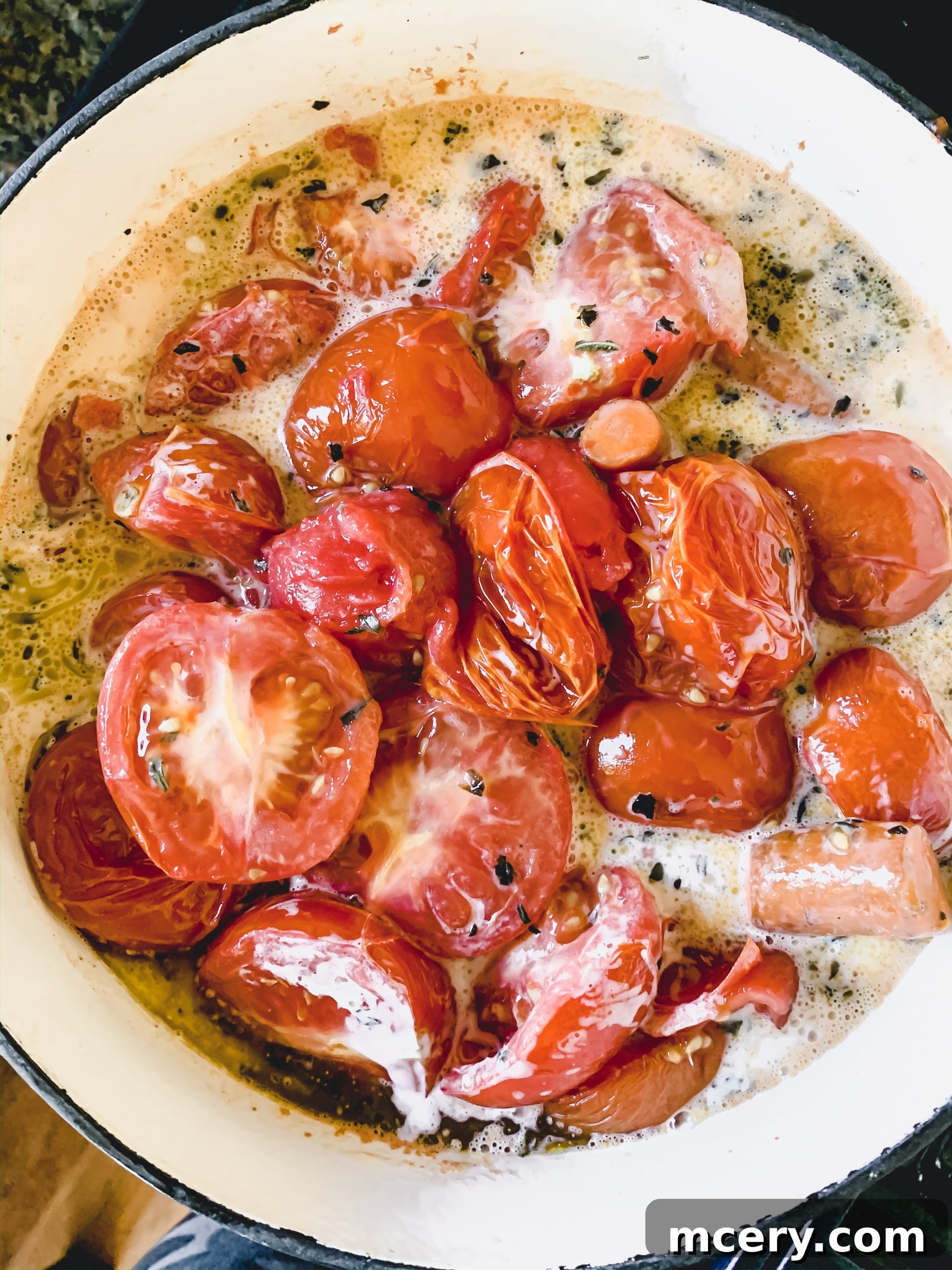 Raw ingredients for Roasted Tomato Soup before preparation, including whole tomatoes, carrots, and a head of garlic, ready for roasting.