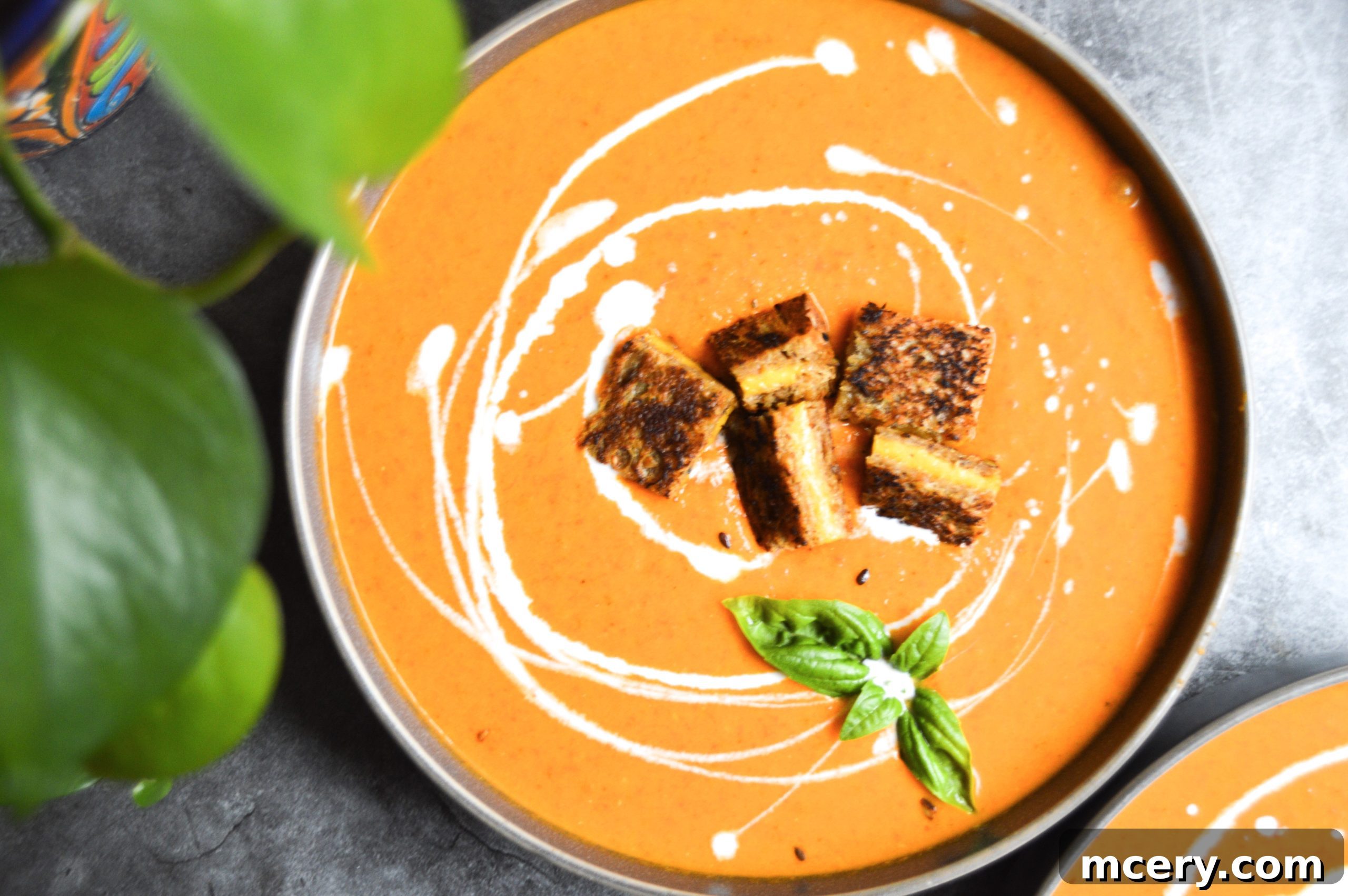 A close-up shot of the smooth, creamy, and vibrant red texture of the finished Roasted Tomato Soup in a large cooking pot, ready to be served and enjoyed.