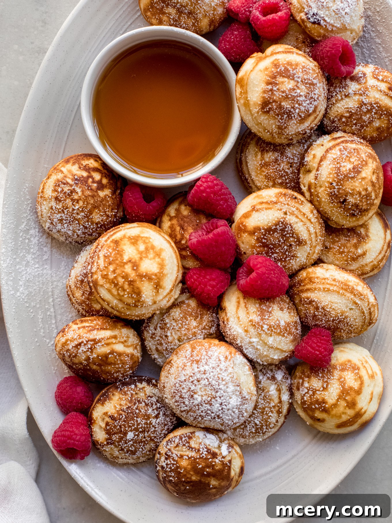 A delicious stack of Danish ball pancakes, lightly dusted with powdered sugar, ready for serving.