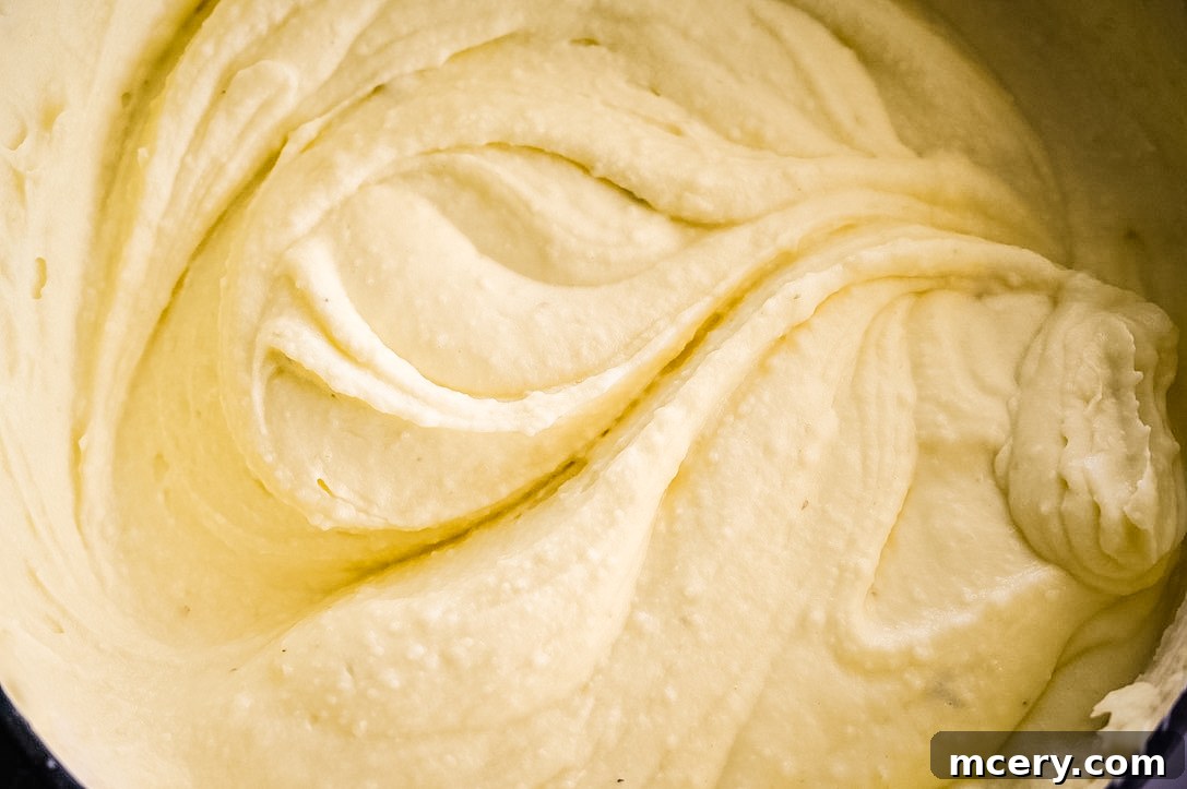 Melt-in-Your-Mouth Mashed Potatoes 4 A large serving bowl filled with a generous portion of creamy, golden mashed potatoes, ready for a Thanksgiving feast. The rich texture suggests warmth and comfort.