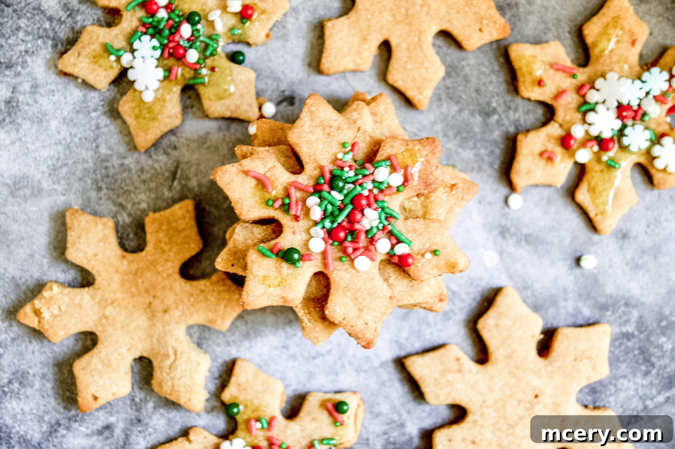 Guilt-Free Paleo Vegan Cut-Out Sugar Cookies 6 Several unbaked paleo sugar cookies, cut into star and snowflake shapes, neatly arranged on a parchment-lined baking sheet, awaiting their turn in the oven.