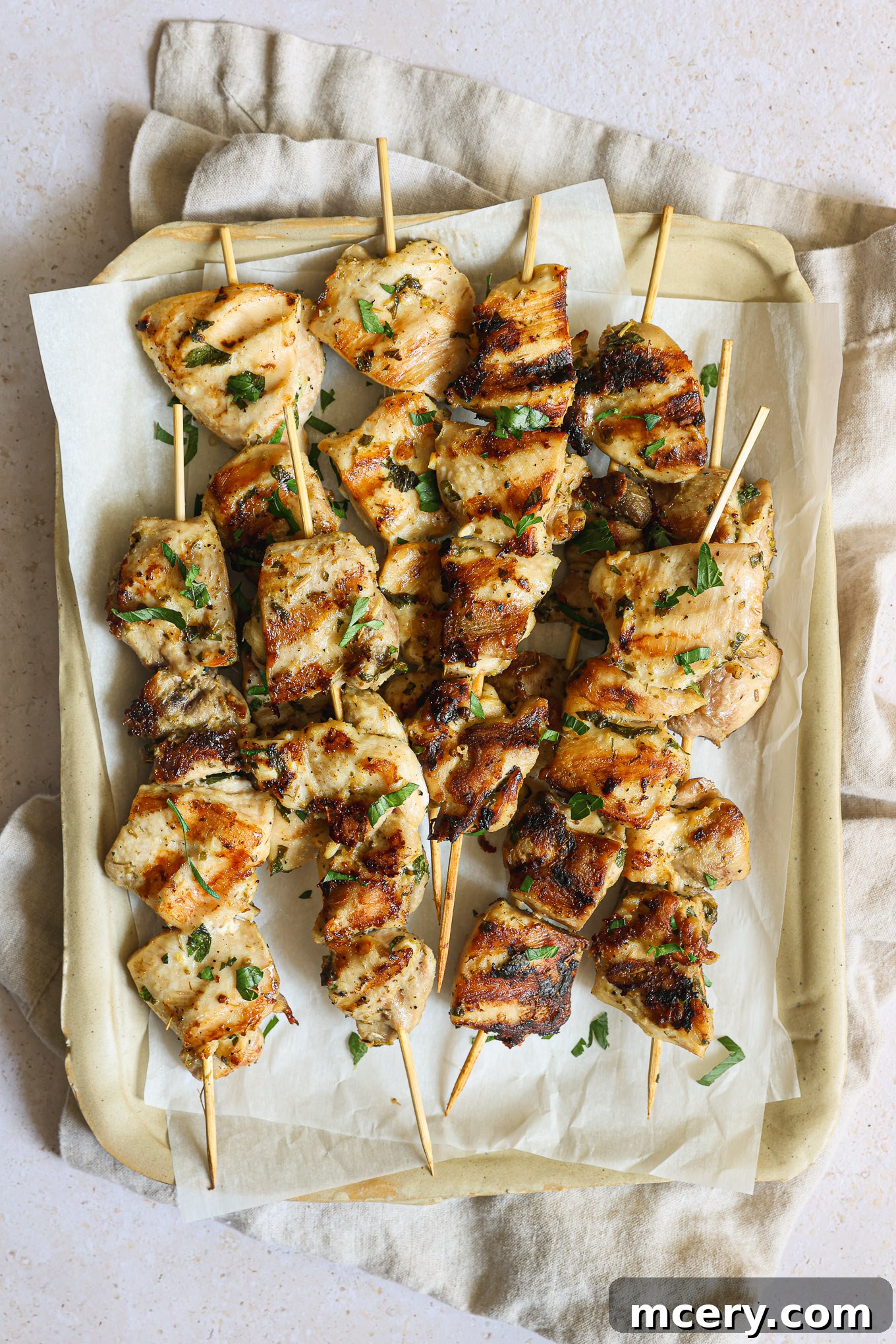 Grilled chicken kabobs arranged neatly on a serving tray, garnished with fresh herbs.