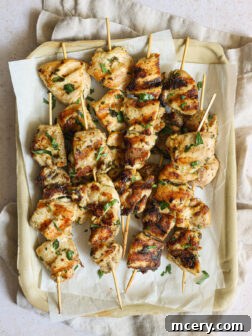Grilled chicken kabobs on tray.