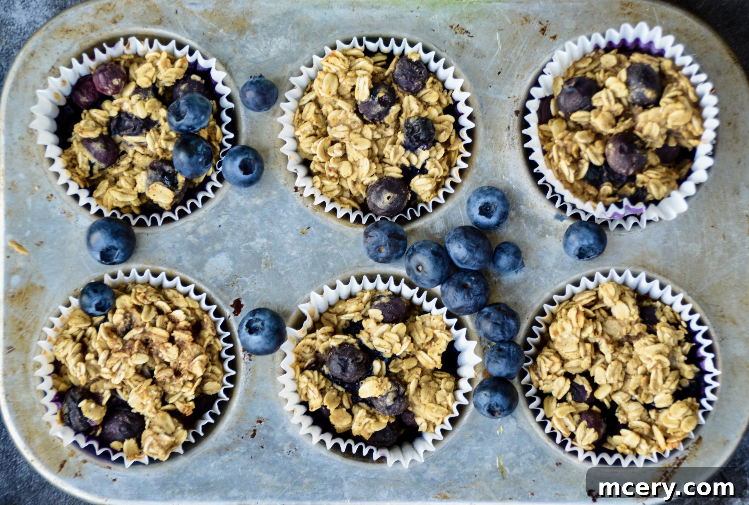Grab-and-Go Blueberry Protein Oatmeal Cups 3 Close-up shot of a single Blueberry Protein Oatmeal Cup being held, showcasing its fluffy texture and visible blueberries.