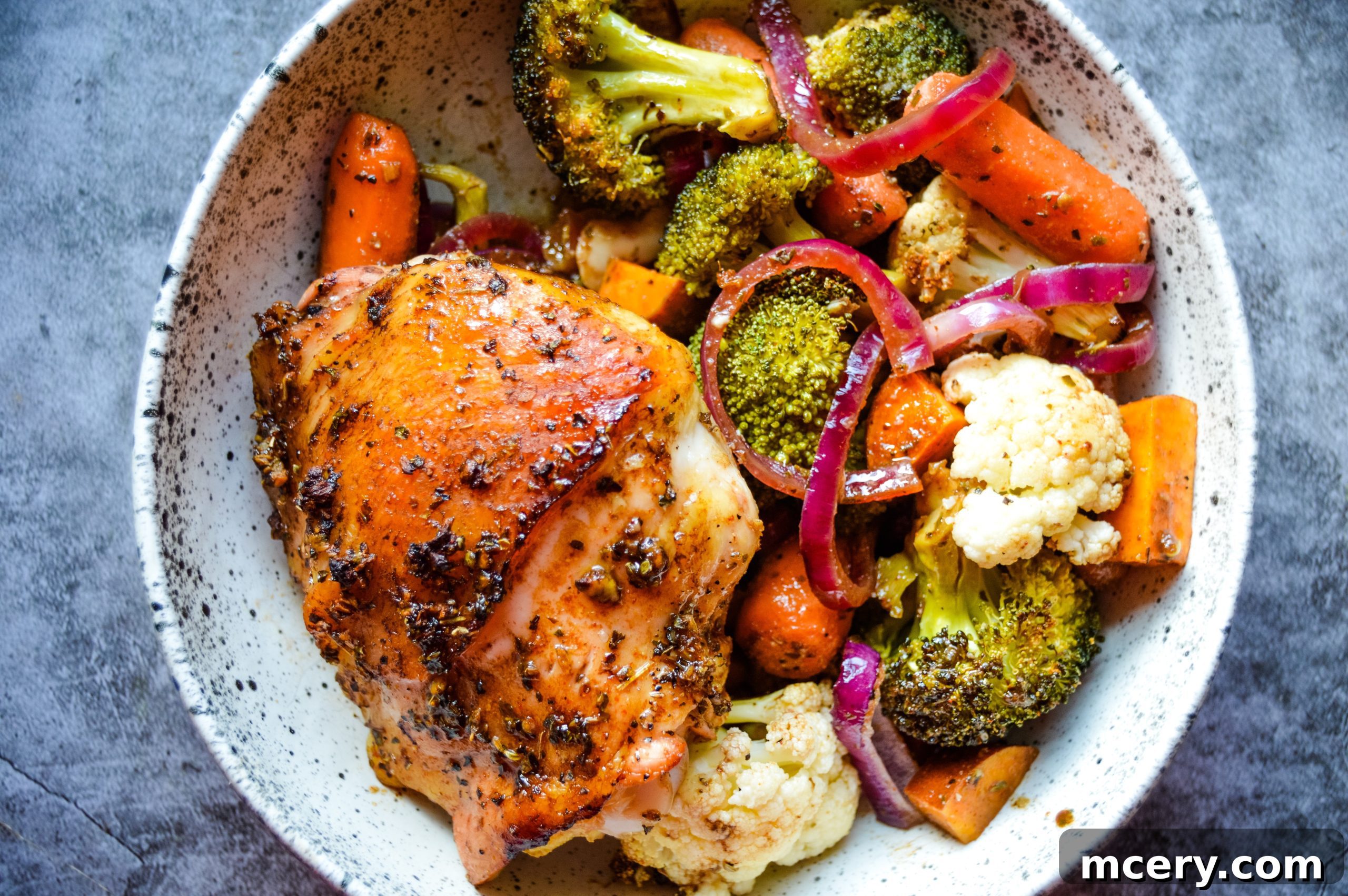 Golden brown Balsamic Honey Sheet Pan Chicken and vibrant roasted vegetables on a baking sheet, ready to serve.