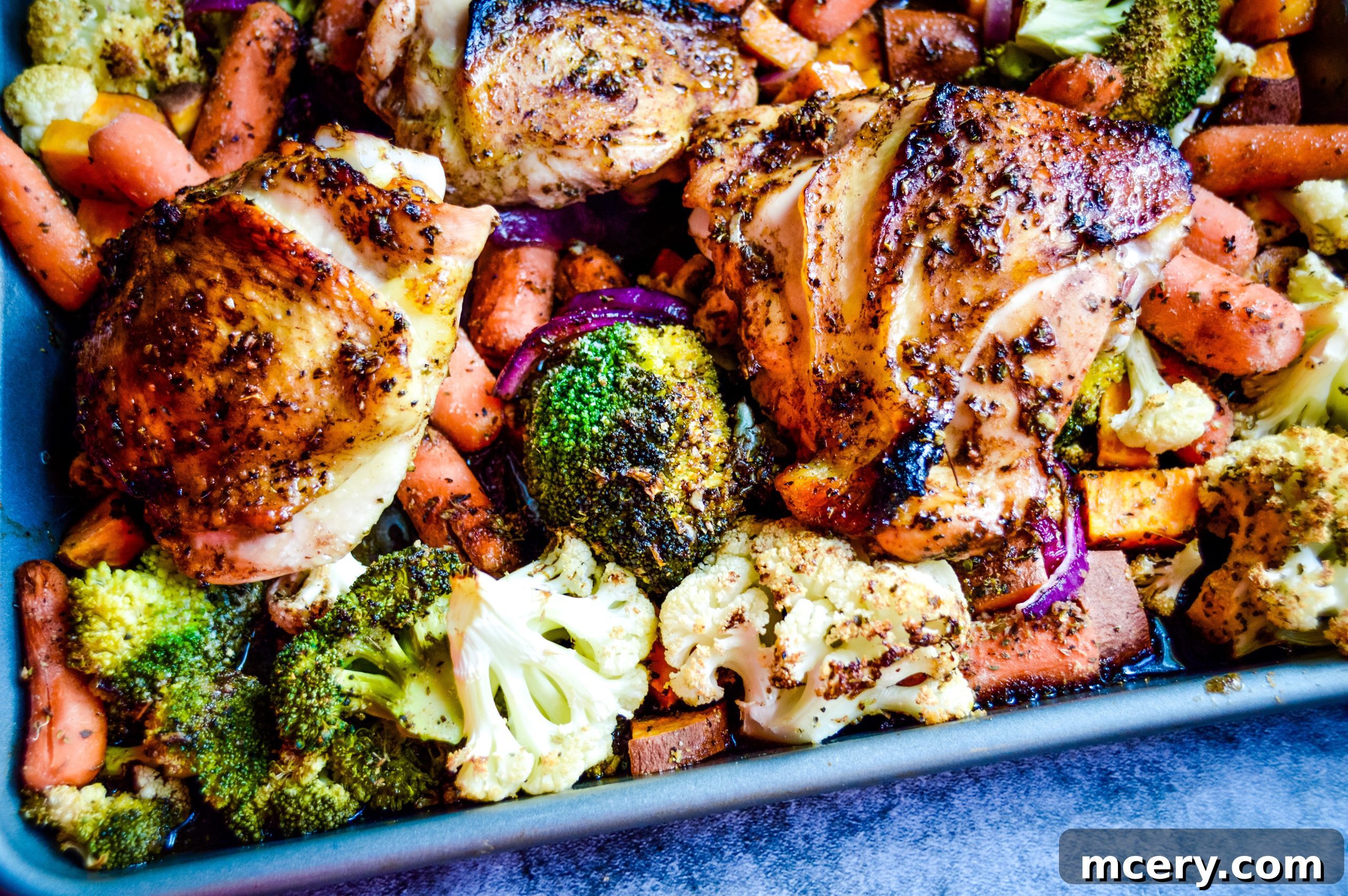 Cooked Balsamic Honey Sheet Pan Chicken and Veggies arranged on a serving plate.