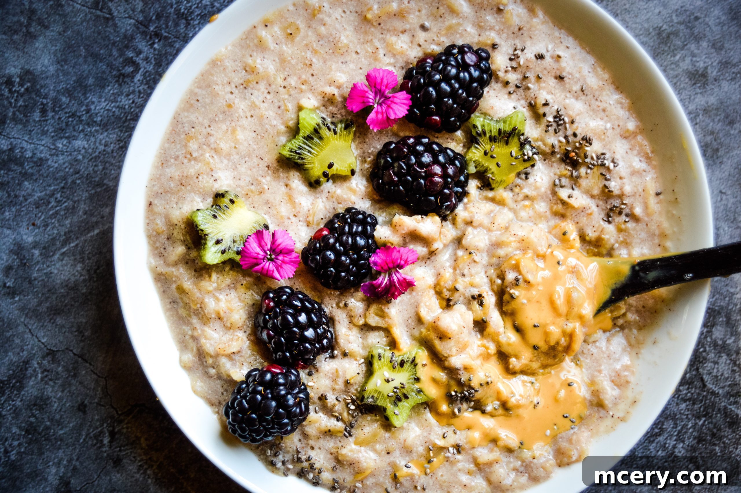 Cozy Cinnamon Banana Oats 2 A beautifully presented bowl of Banana Cinnamon Oatmeal topped with fresh berries and nut butter, ready to be enjoyed for breakfast.