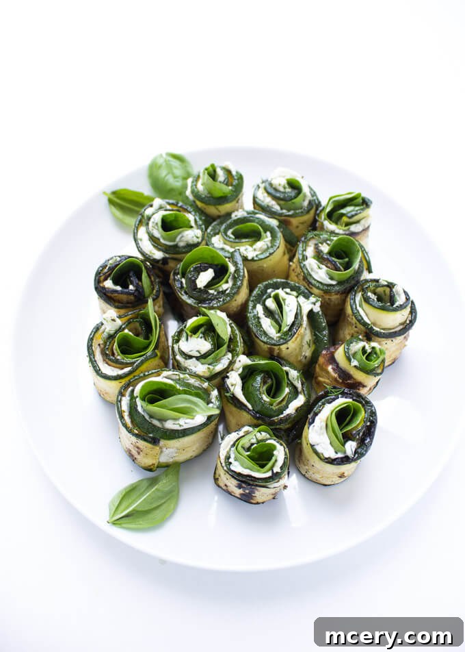 Creamy Zucchini Pinwheels 4 A platter of beautifully grilled zucchini roll-ups, highlighting the simple elegance and vibrant flavors of the herb cream cheese, spinach, and basil.