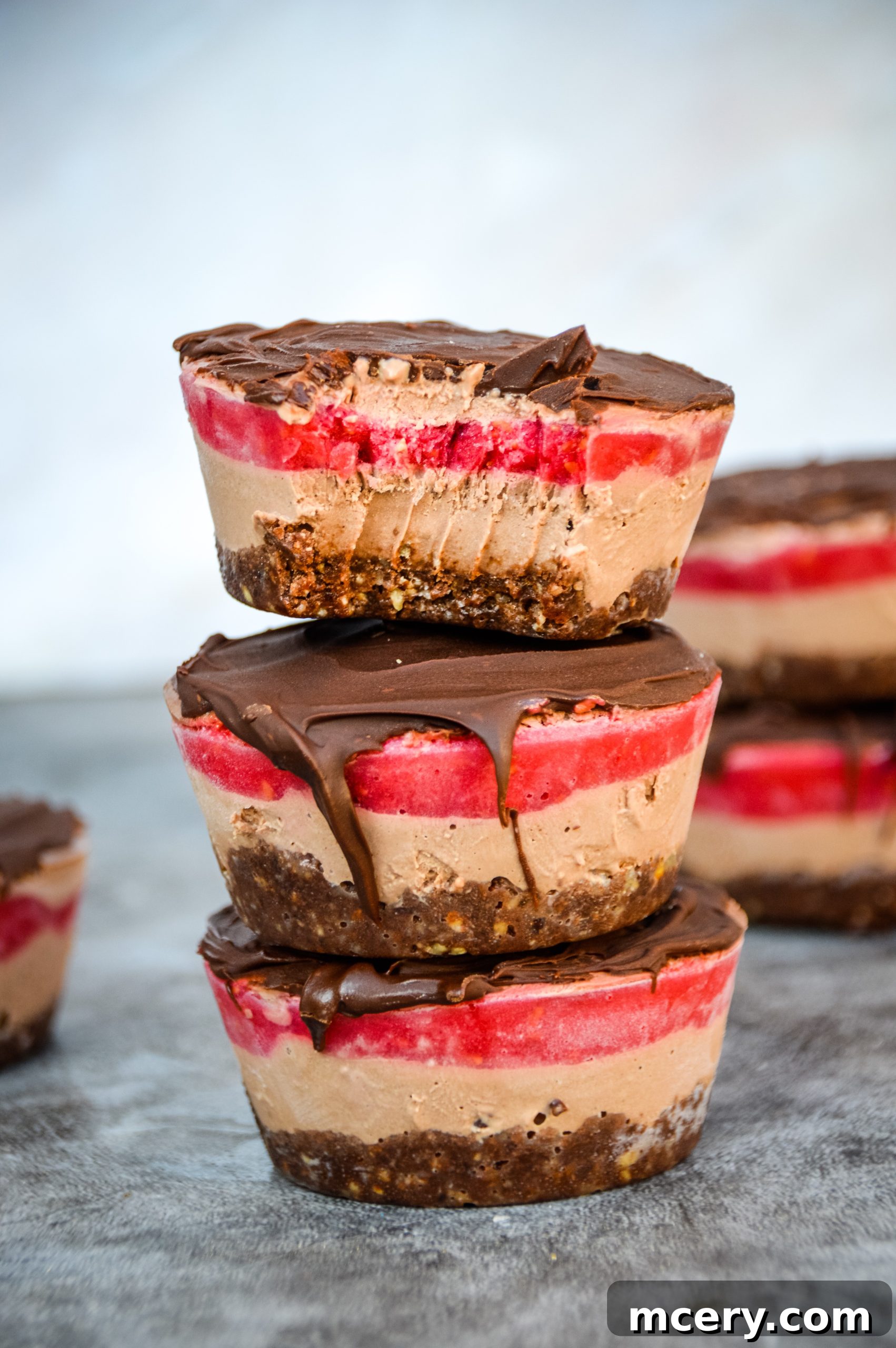 Close-up of layered No-Bake Vegan Chocolate Raspberry Cakes, highlighting creamy textures and fresh raspberries