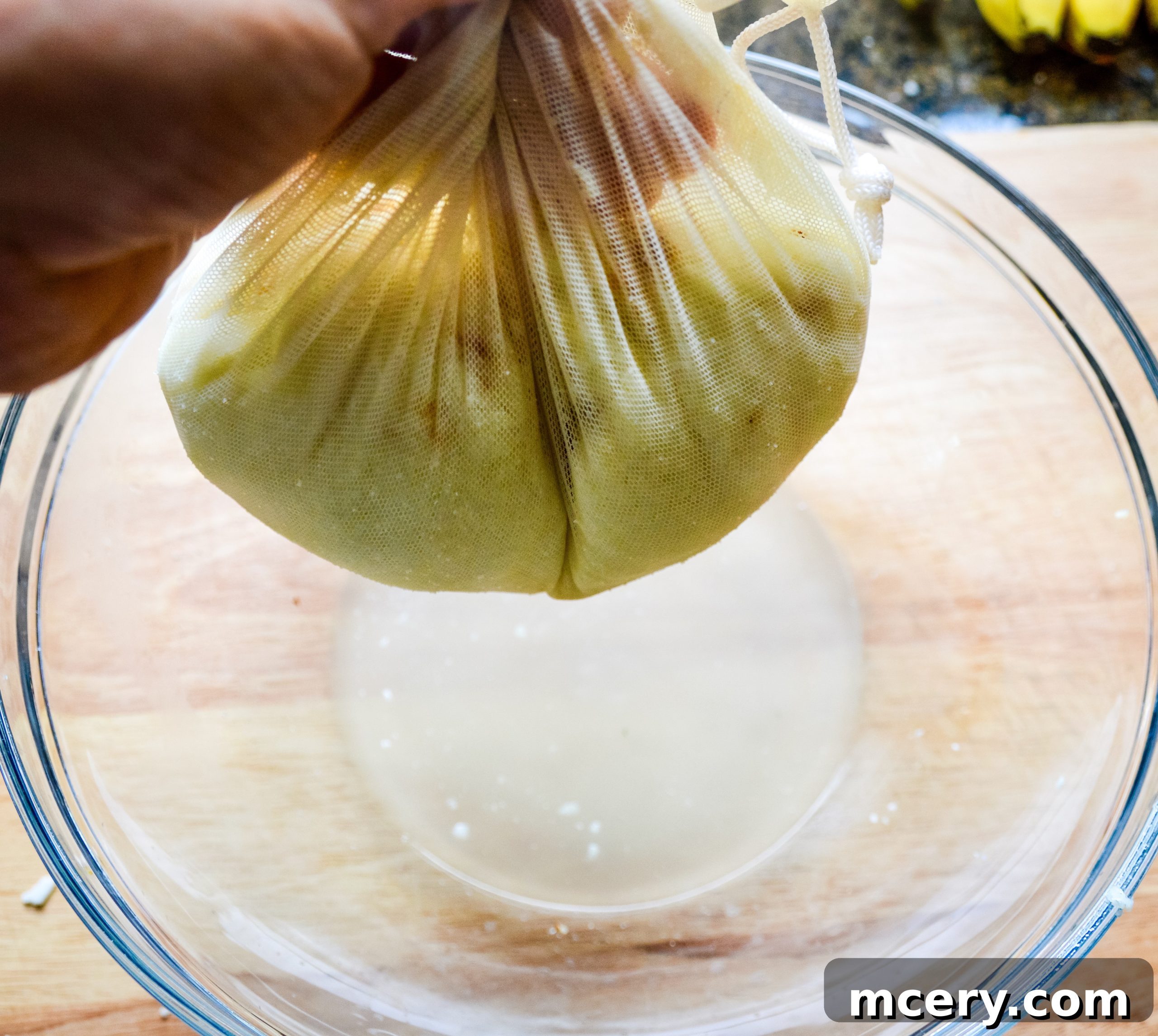 The Ultimate Cauliflower Pizza Base 9 Draining water from cauliflower rice using a clean cloth.