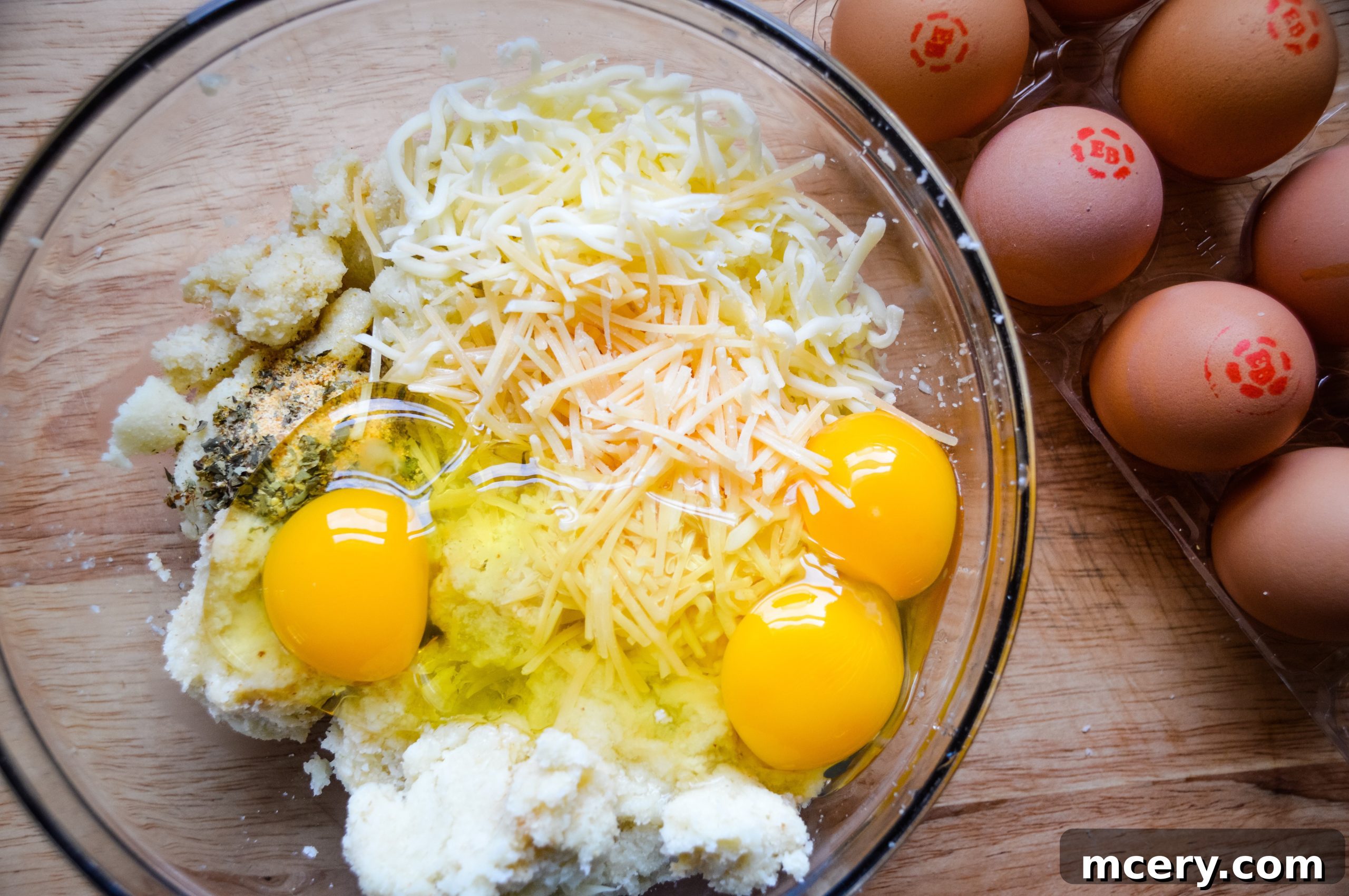 The Ultimate Cauliflower Pizza Base 10 Mixing cauliflower, eggs, cheese, and spices in a bowl.