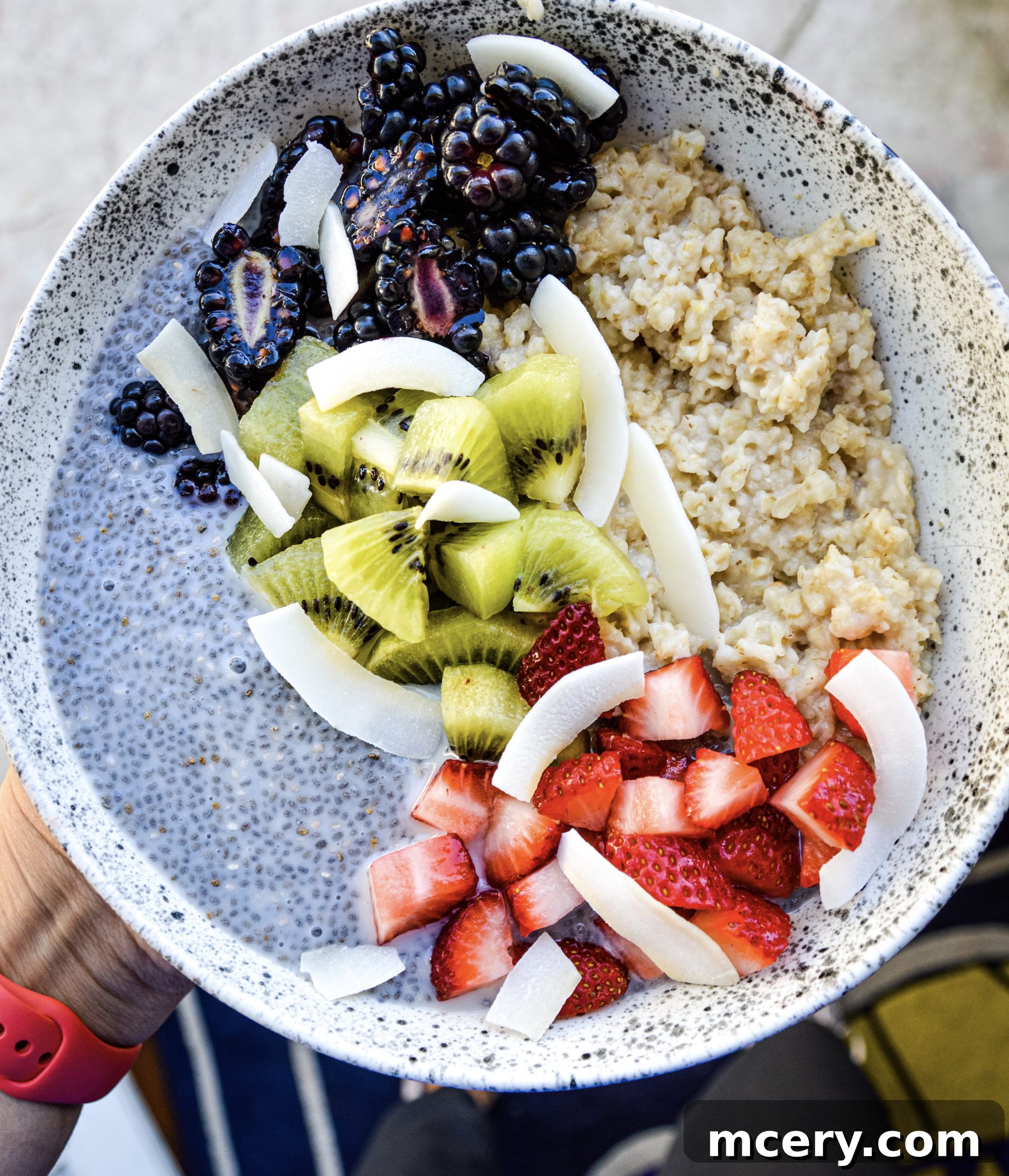 Wholesome Chia Oat Power Bowl 4 A close-up of a spoon digging into the layered Chia Pudding and Oats Breakfast Bowl with fruit and coconut flakes.