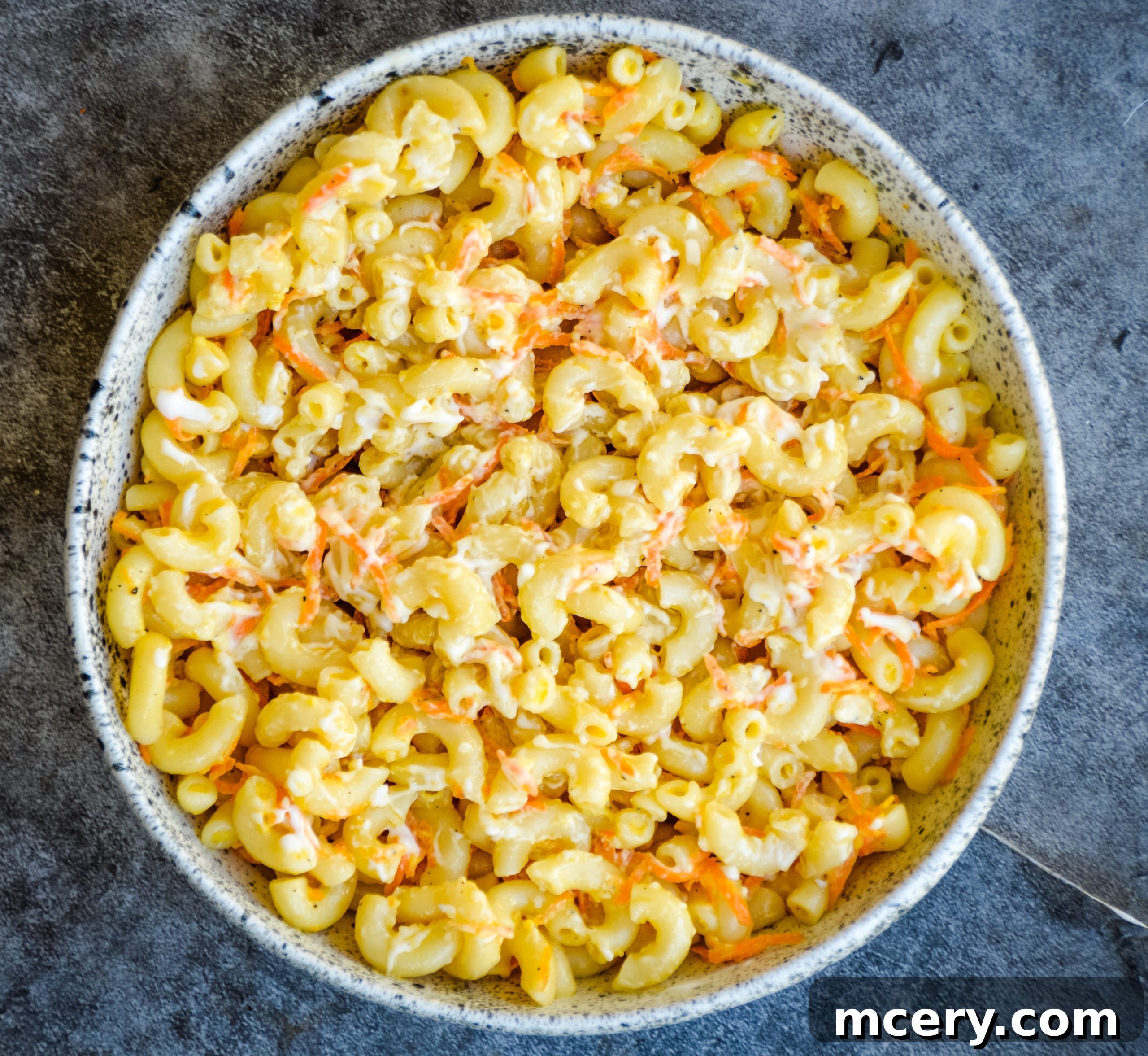 Guilt-Free Hawaiian Macaroni Salad 5 A collection of the five main ingredients for Hawaiian Macaroni Salad, including pasta, carrots, onion, and mayonnaise, neatly arranged on a counter.