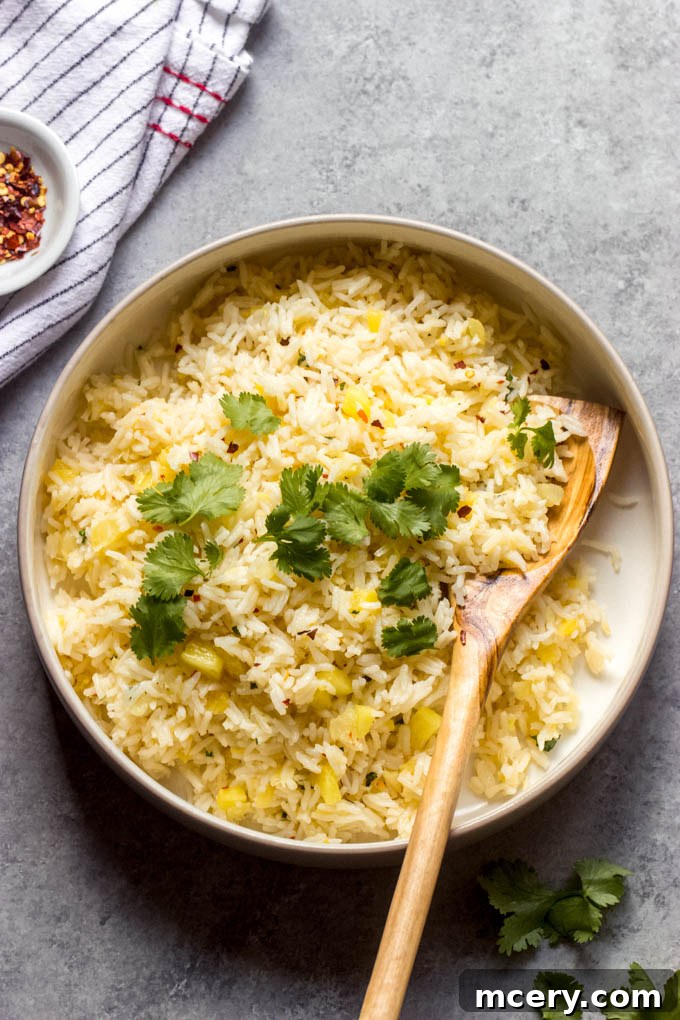 Tropical Pineapple Rice 2 overhead shot of a vibrant bowl of pineapple rice, garnished with fresh cilantro and red chili flakes