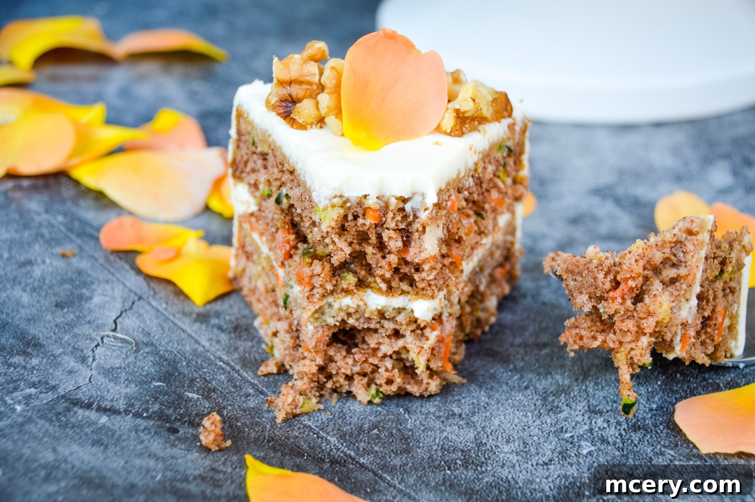 Wholesome Carrot and Zucchini Cake 2 A slice of Healthy Carrot & Zucchini Cake on a plate, showcasing its moist texture and creamy frosting.