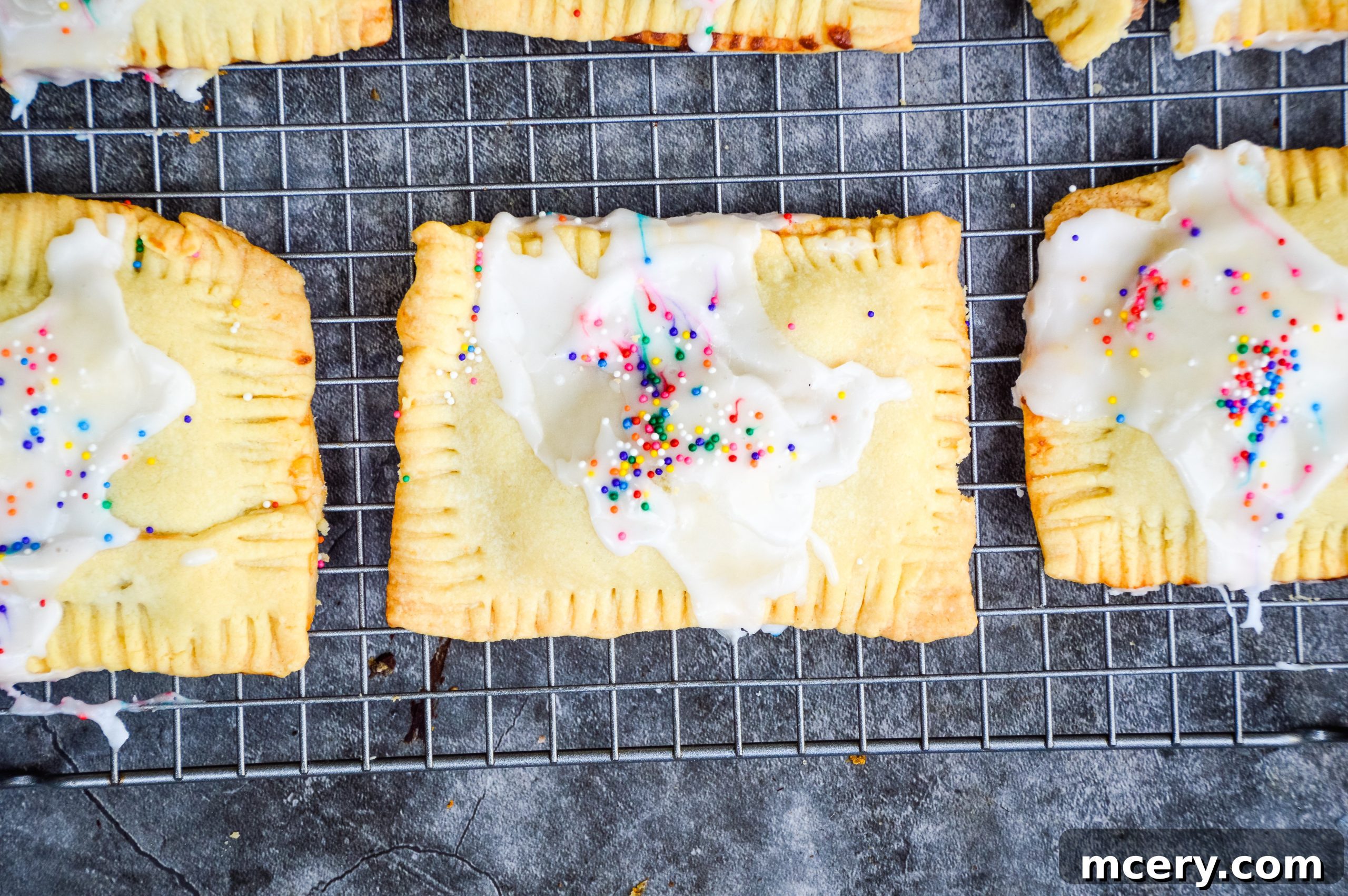 Sweet Strawberry Toaster Treat 4 Unbaked pop-tarts with strawberry jam filling visible, arranged on a baking sheet.