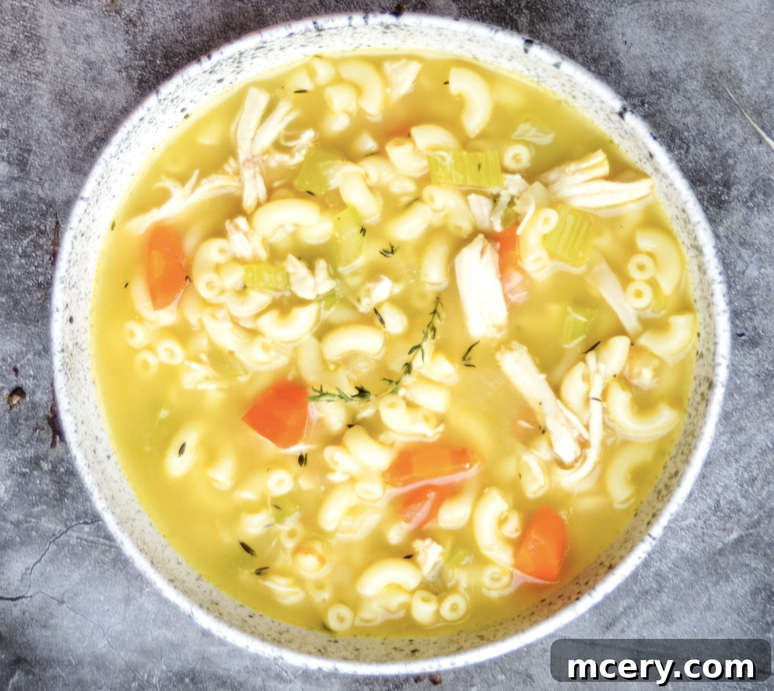 Another angle of the chicken noodle soup, showcasing the rich, golden broth and various ingredients in a bowl.
